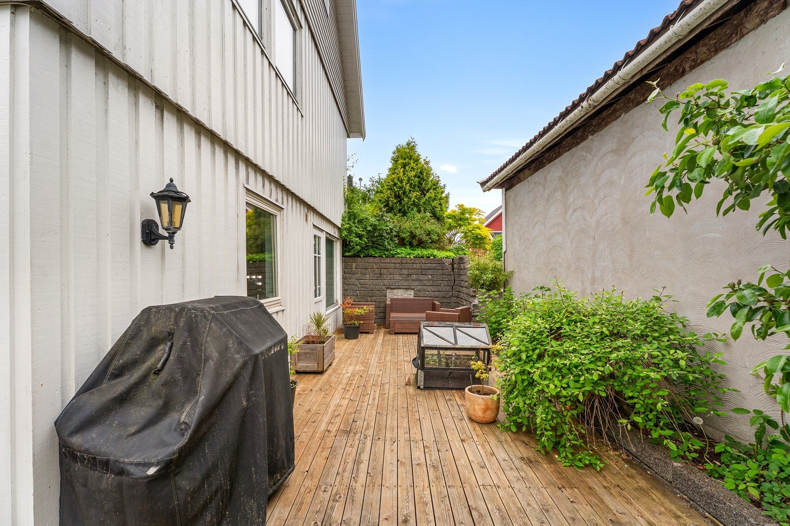 Romslig uteplass tilknyttet utleiedel, med terrasse og skjermede omgivelser Galleribilde