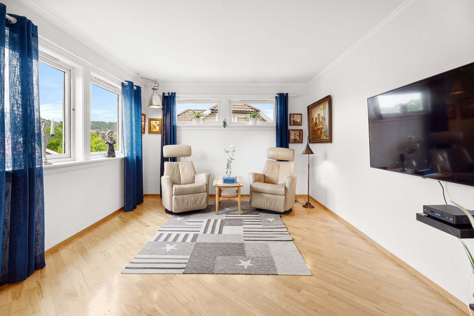 Lys stuedel med egen TV-sone og plass til lenestoler eller sofa Galleribilde