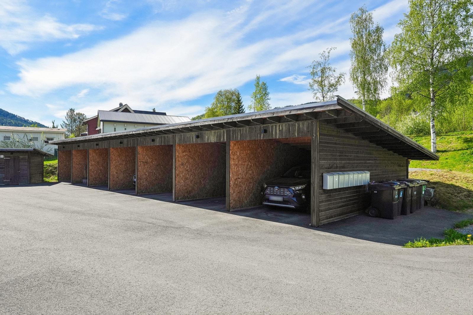 Leiligheten disponerer også carport med elbillader. I bakkant av carporten disponerer også leiligheten en sportsbod Galleribilde