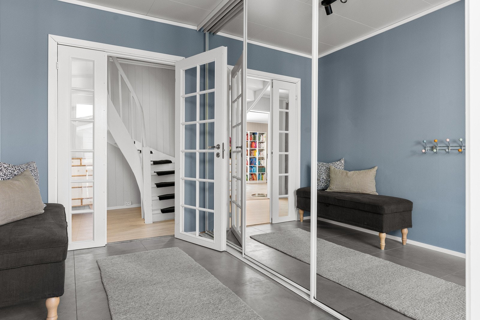 Velkommen inn. Stor hall med skyvedørsgarderobe.