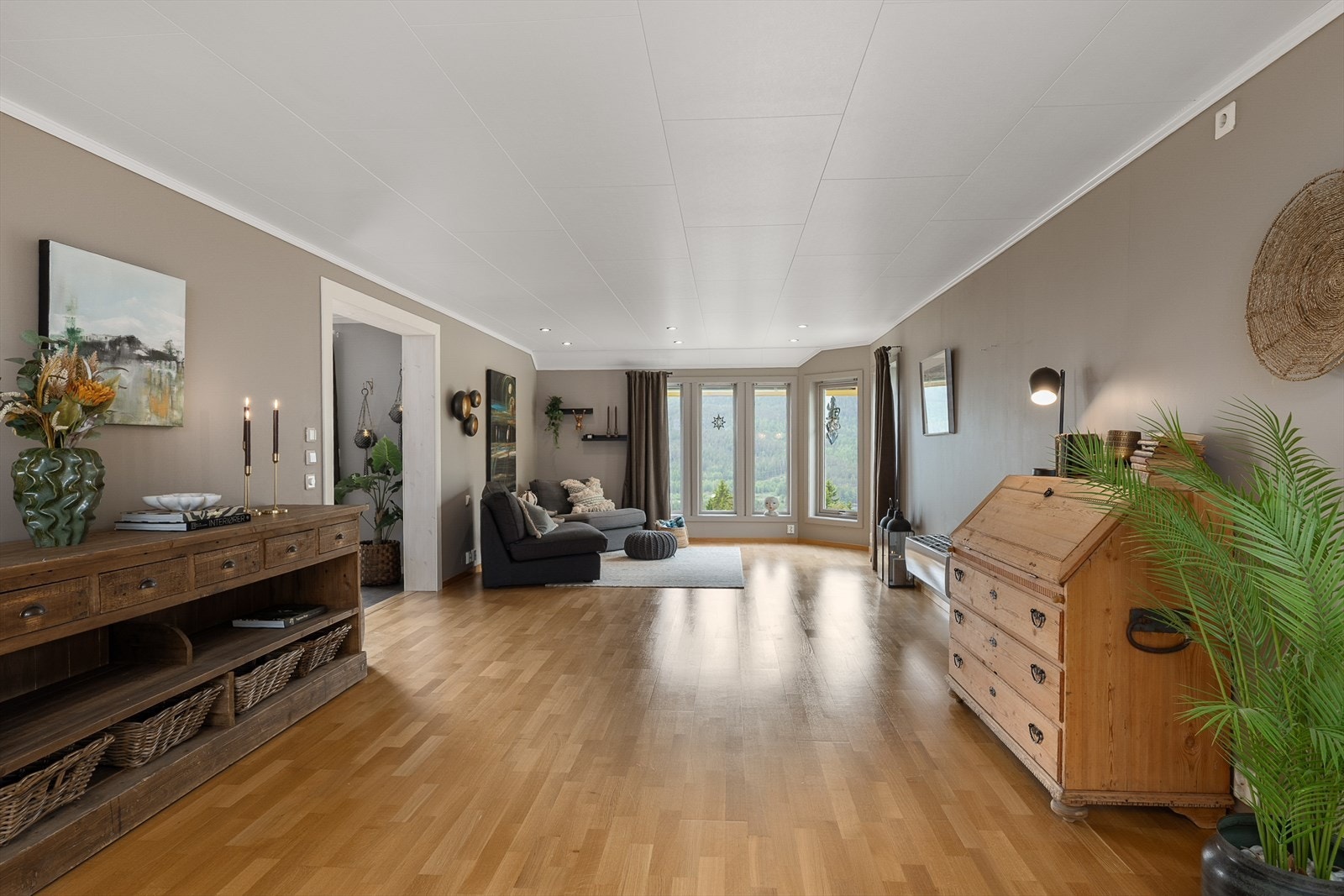 Stor og lys stue med parkett på gulvet og god plass til flere sittegrupper. Galleribilde