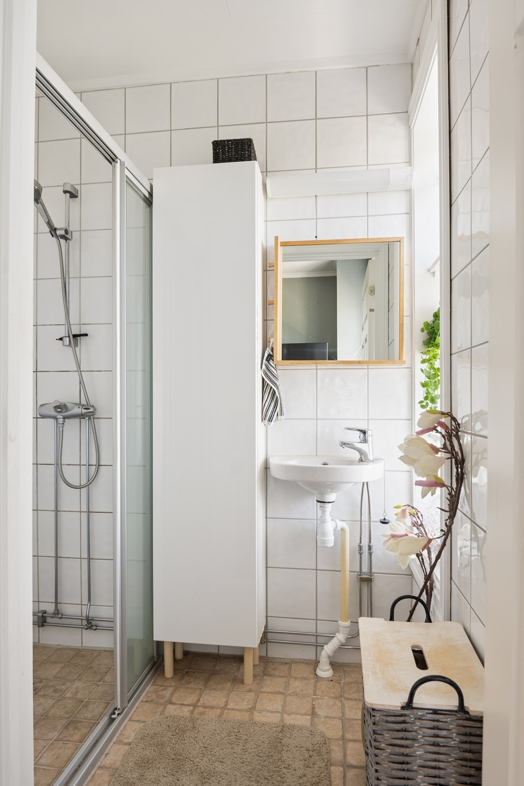 Badet har adkomst fra kjøkkenet, og har dusjnisje, håndvask og høyskap Galleribilde