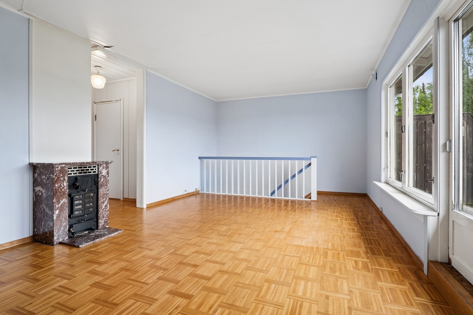 Overflatene i stuen består av parkettgulv og malte vegger. Galleribilde