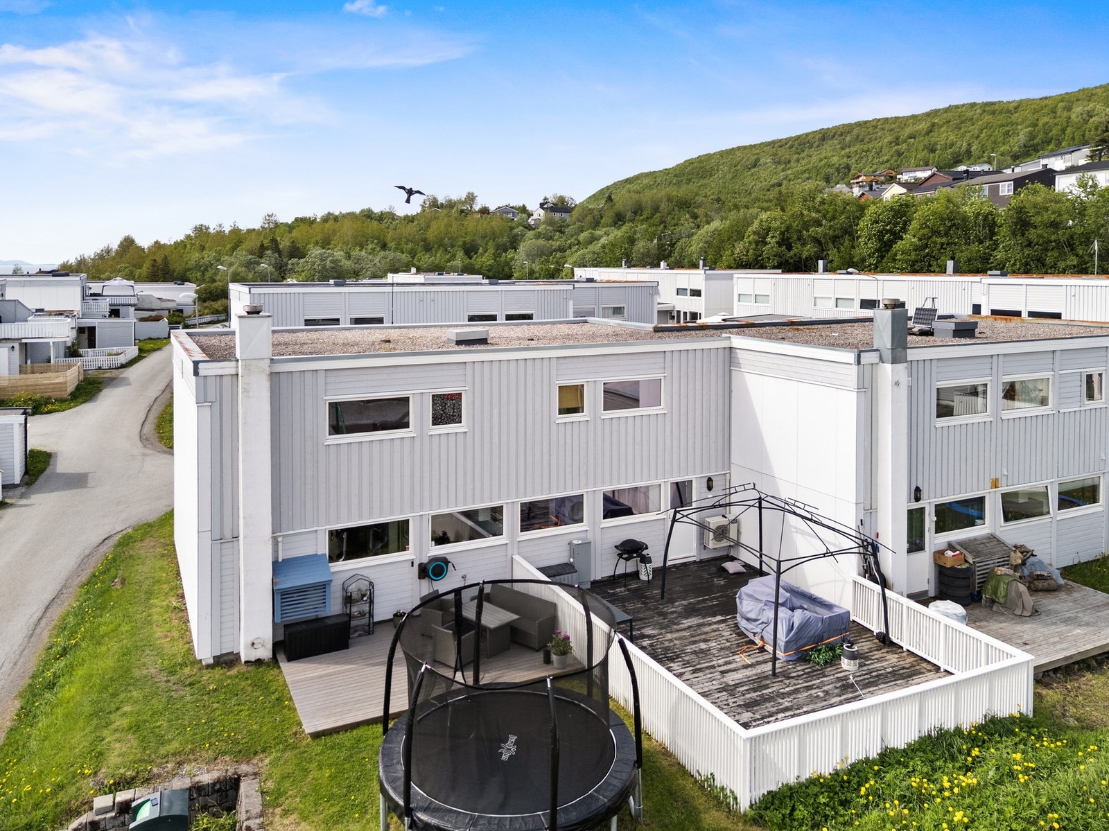 I tillegg til terrassen ved inngangspartiet, er det terrasse og gressplen på baksiden av boligen. Galleribilde