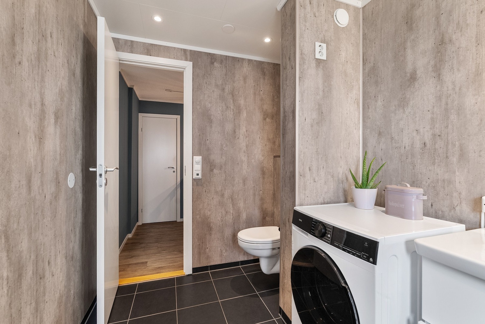 Badet er utstyrt med veggmontert toalett og opplegg for vaskemaskin. Galleribilde