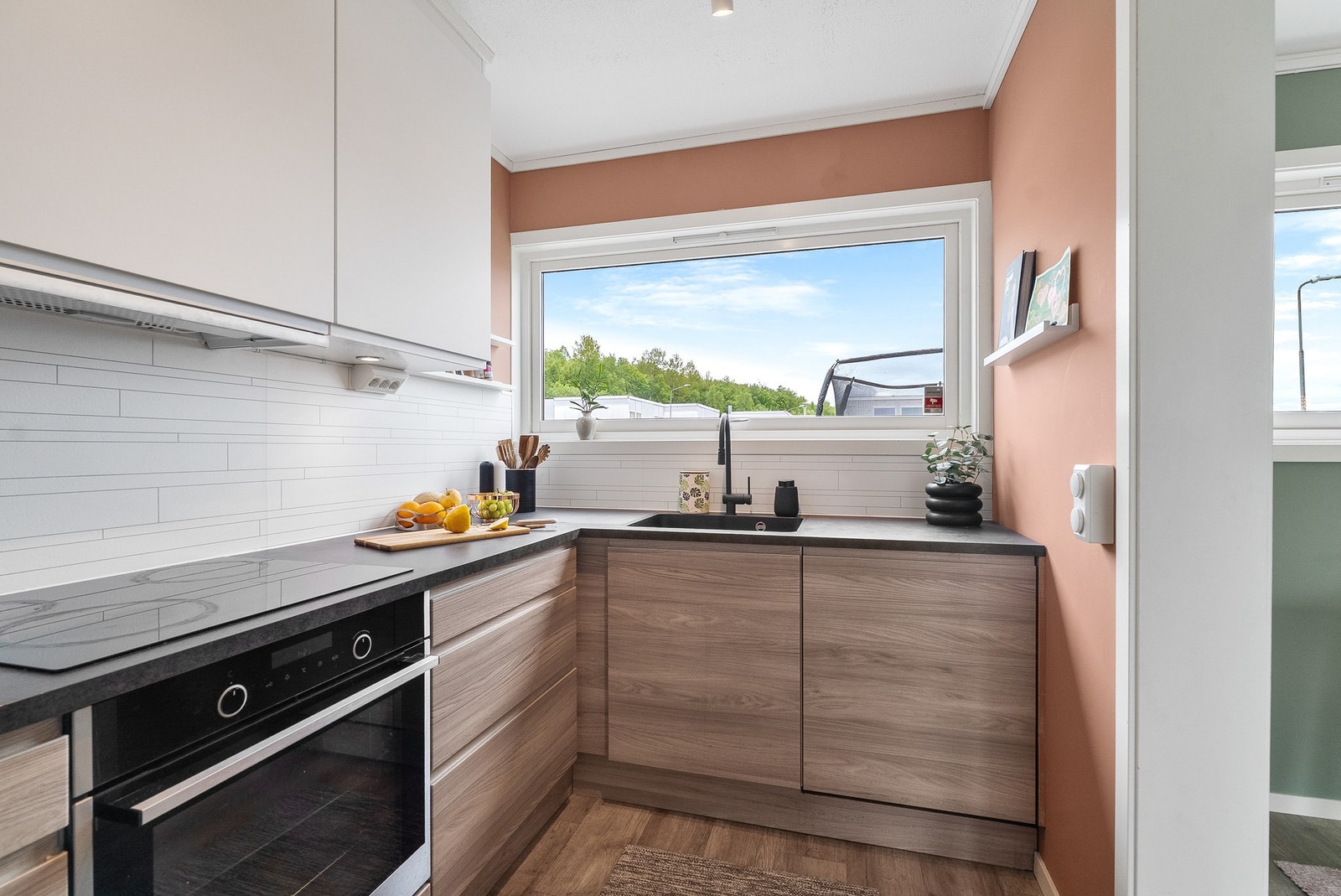 Kitchenboard-plater over benken beskytter veggen og er enkle å holde rene. Benkeplaten i laminat har underlimt vask. Galleribilde