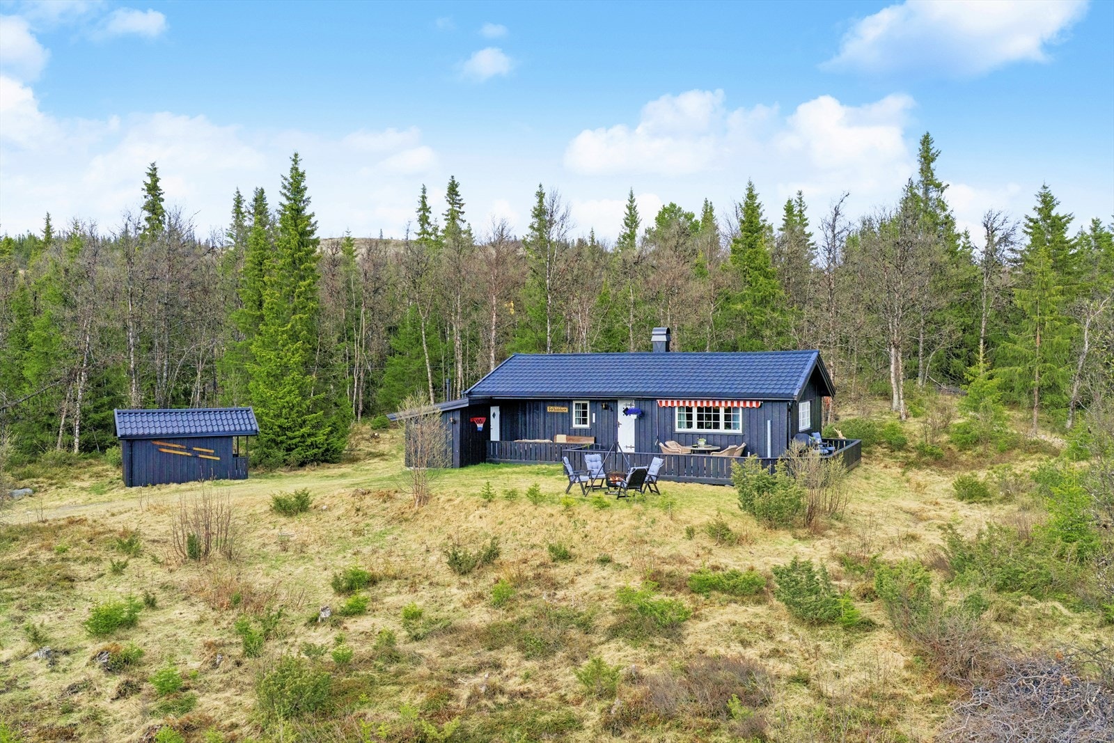 Fritidseiendommen ligger på en opparbeidet naturtomt. I tillegg til hytten er det en frittstående uthus/bod på festetomten. Galleribilde