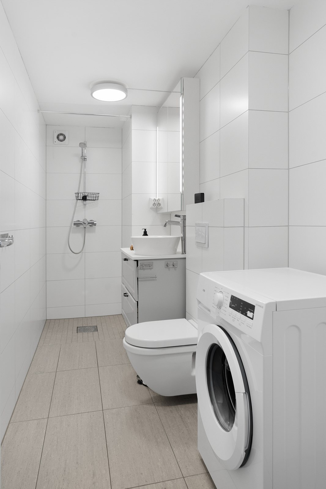 Bad/vaskerom i kjelleren ble etablert i 2018. Rommet har fliser på vegger og malte plater i himlinger. Flislagt gulv med elektrisk varmekabel. Badet er innredet med baderomsmøbel med bolleservant, dusjnisje og veggmontert toalett. Opplegg for vaskemaskin. Galleribilde