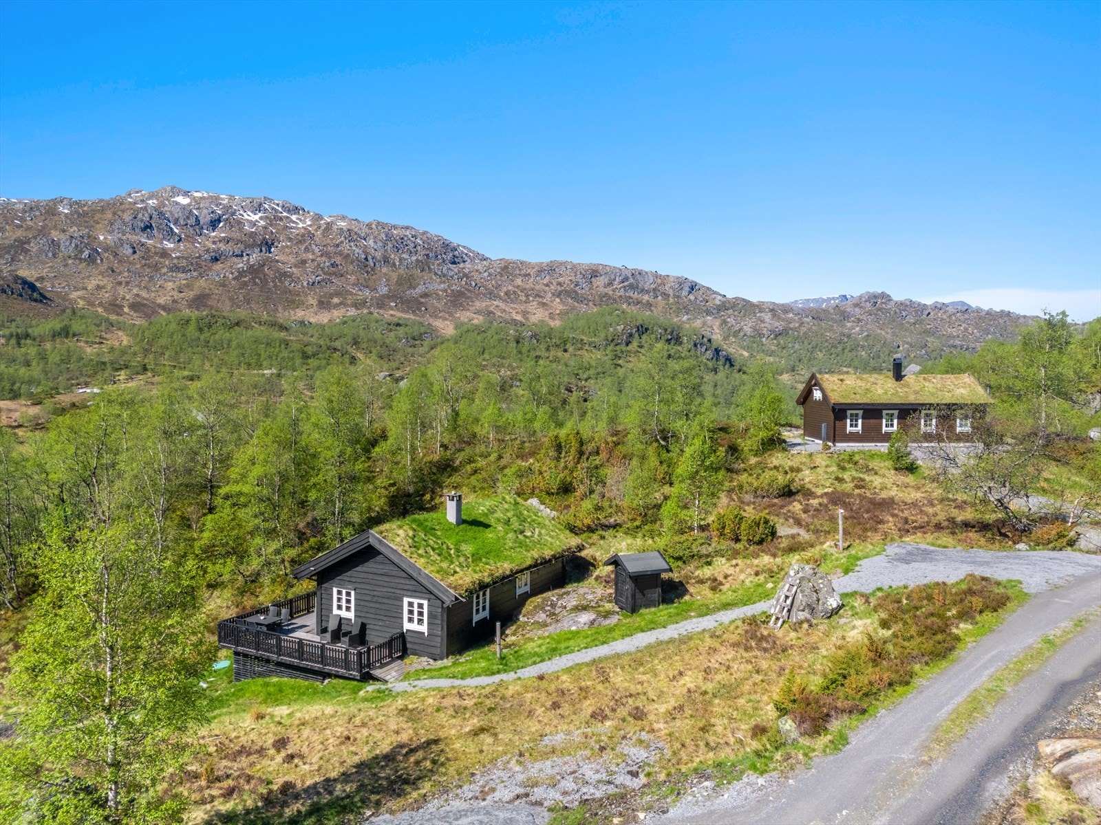 Fritidsbolig fra 1997 med tradisjonelt torvtak og kledning i villmarkspanel, idyllisk plassert i Fjellhaugen. Galleribilde