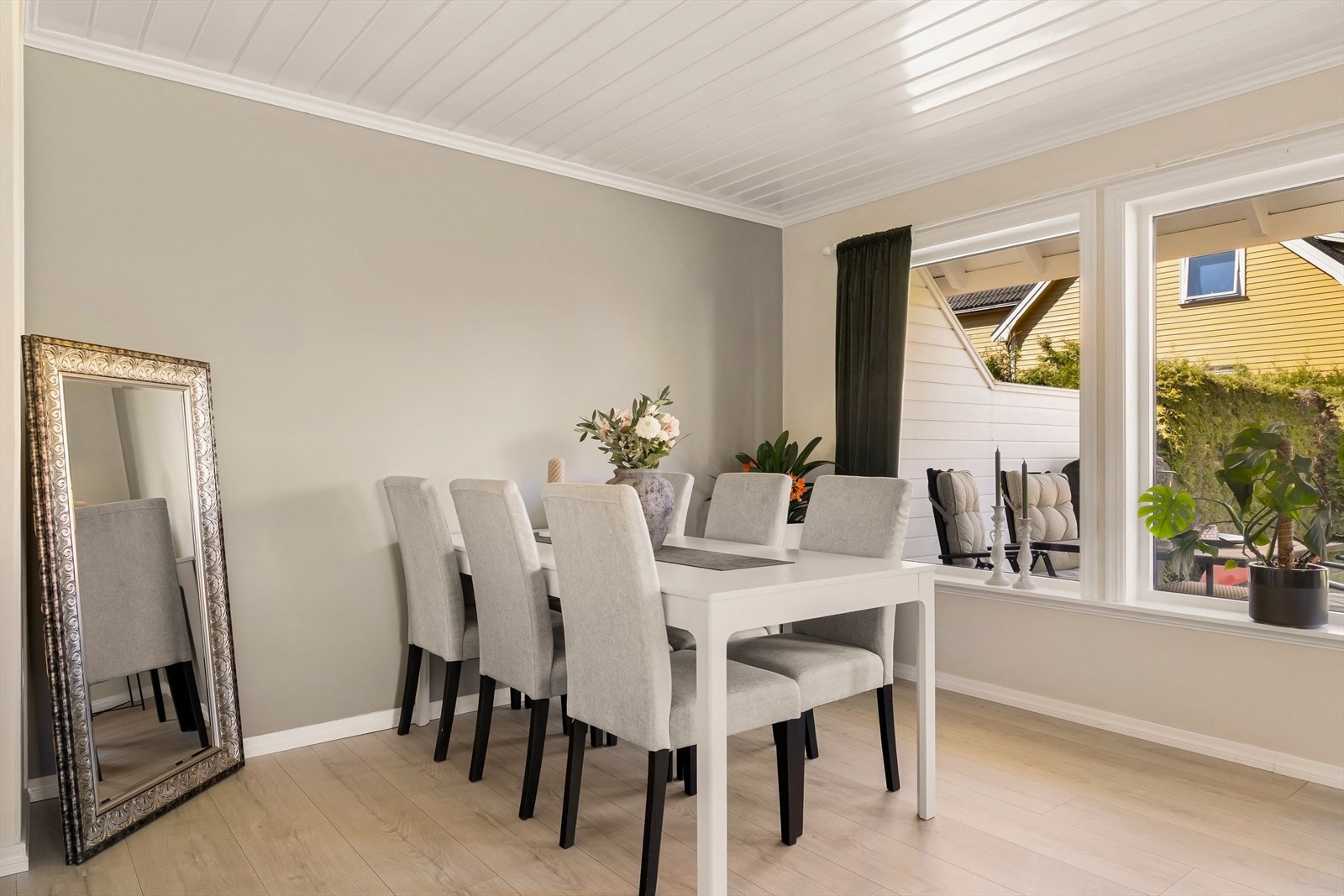Gjennomgående laminatgulv og trepanel i taket skaper en helhetlig stil i boligen. Galleribilde