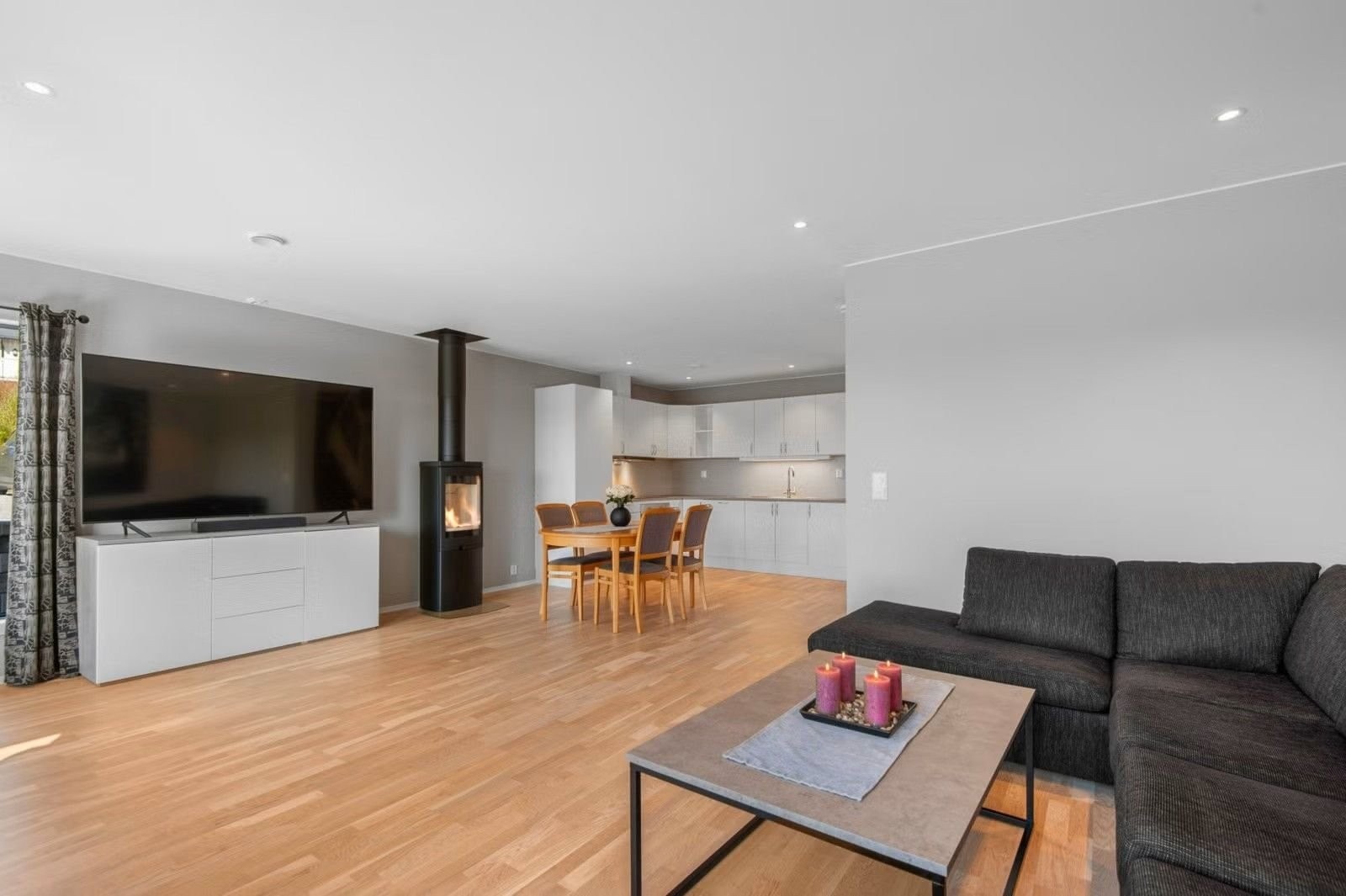Romslig stue med downlights i tak og vedovn. Galleribilde