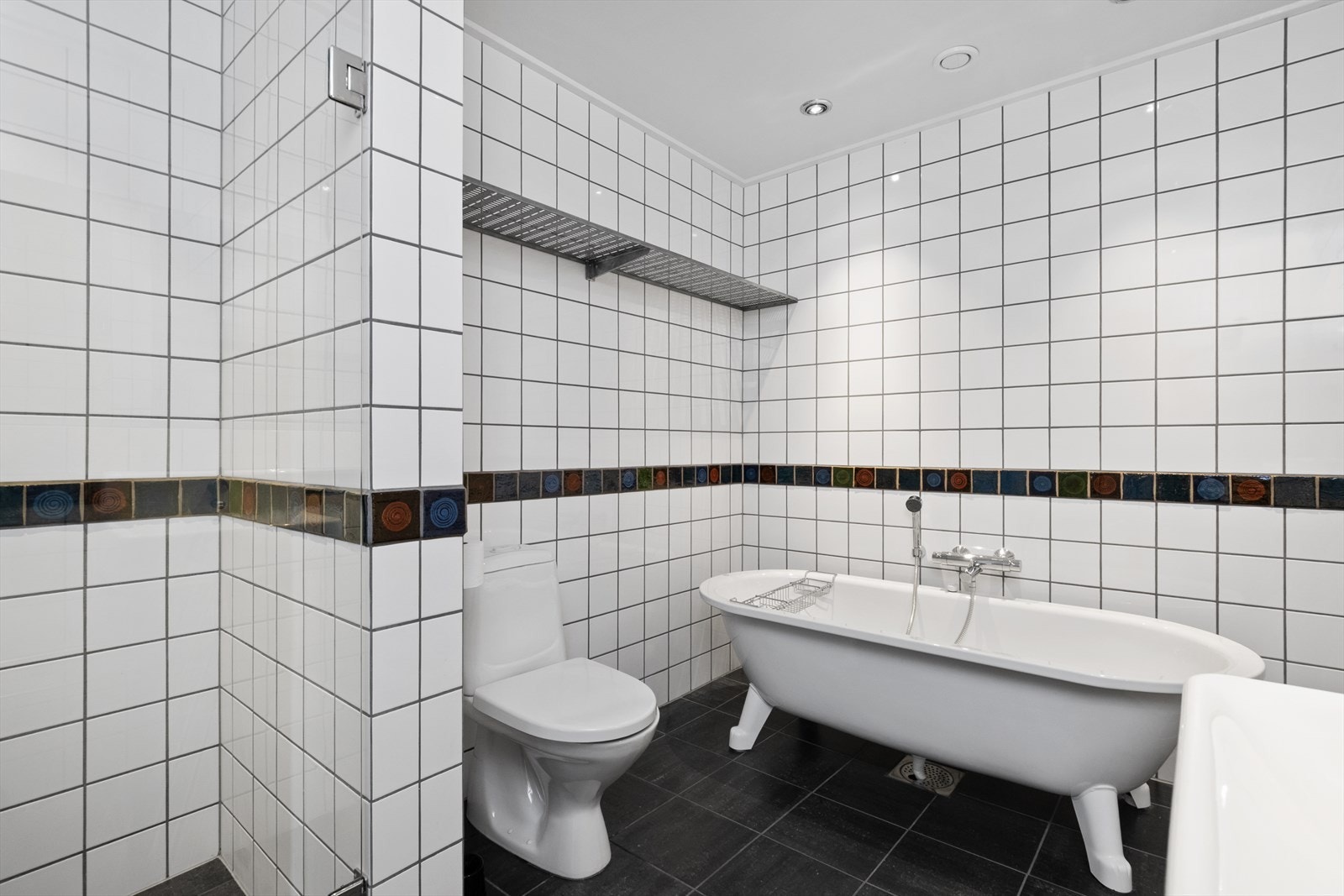 Badet er helfliset og har både badekar og toalett. Galleribilde