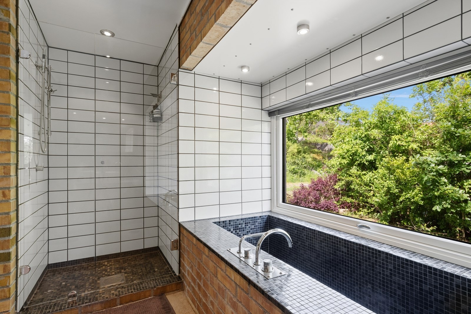 Badet er utstyrt med både dusjnisje med glassdør og et nedsenket badekar. Galleribilde