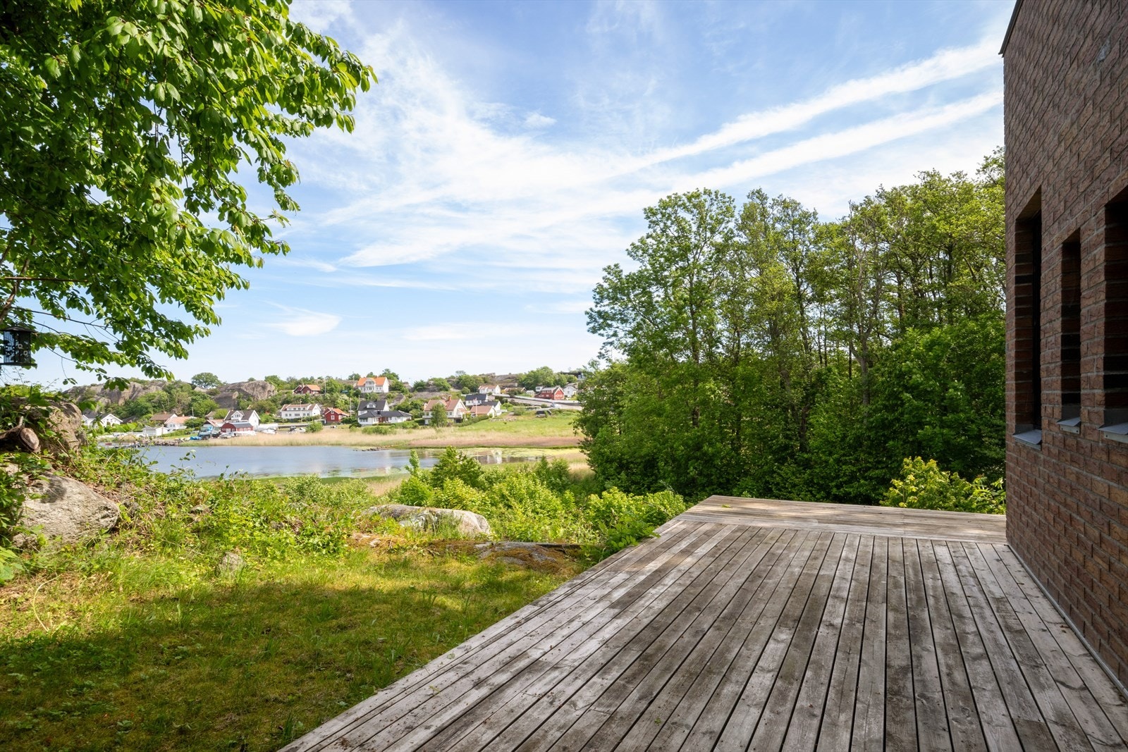 Uteplassen i underetasjen har utsikt mot sjøen og grønne omgivelser. Galleribilde