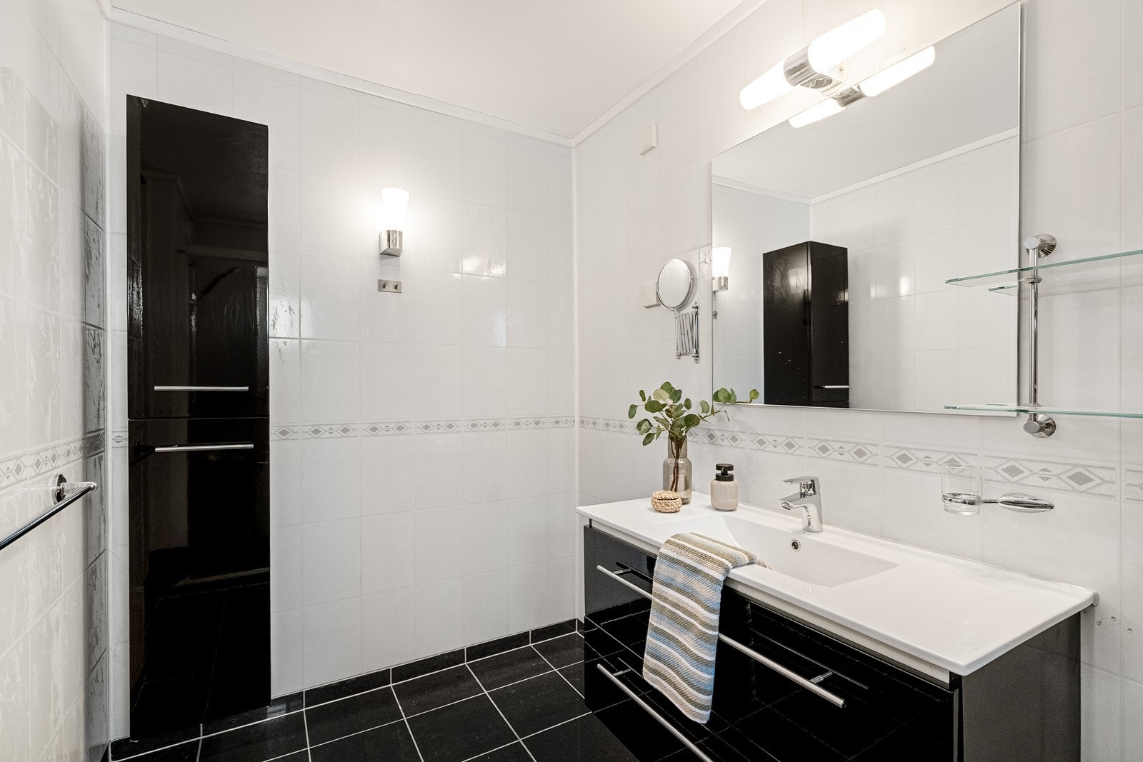 Badet er praktisk innredet med gode oppbevaringsløsninger som gir en ryddig og funksjonell hverdag. Galleribilde