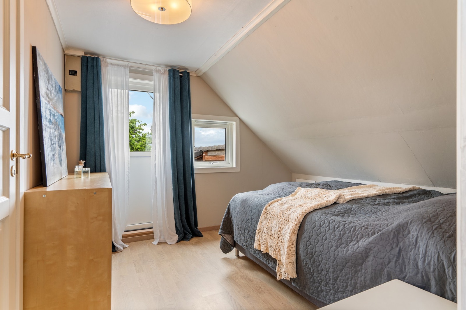 Soverom 1 i loftsetasje, med oppbevaringsrom via dør og utgang til veranda/takterrasse. Nye gulvoverflater og nyere vindu+terrassedør. Galleribilde