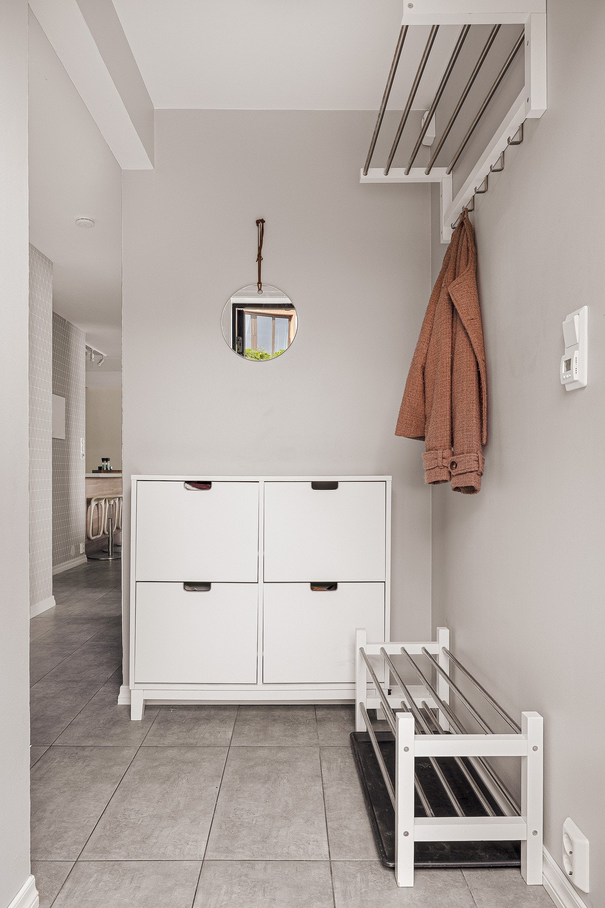 Lyst og pent inngangsparti med god plass til oppbevaring av sko og yttertøy Galleribilde