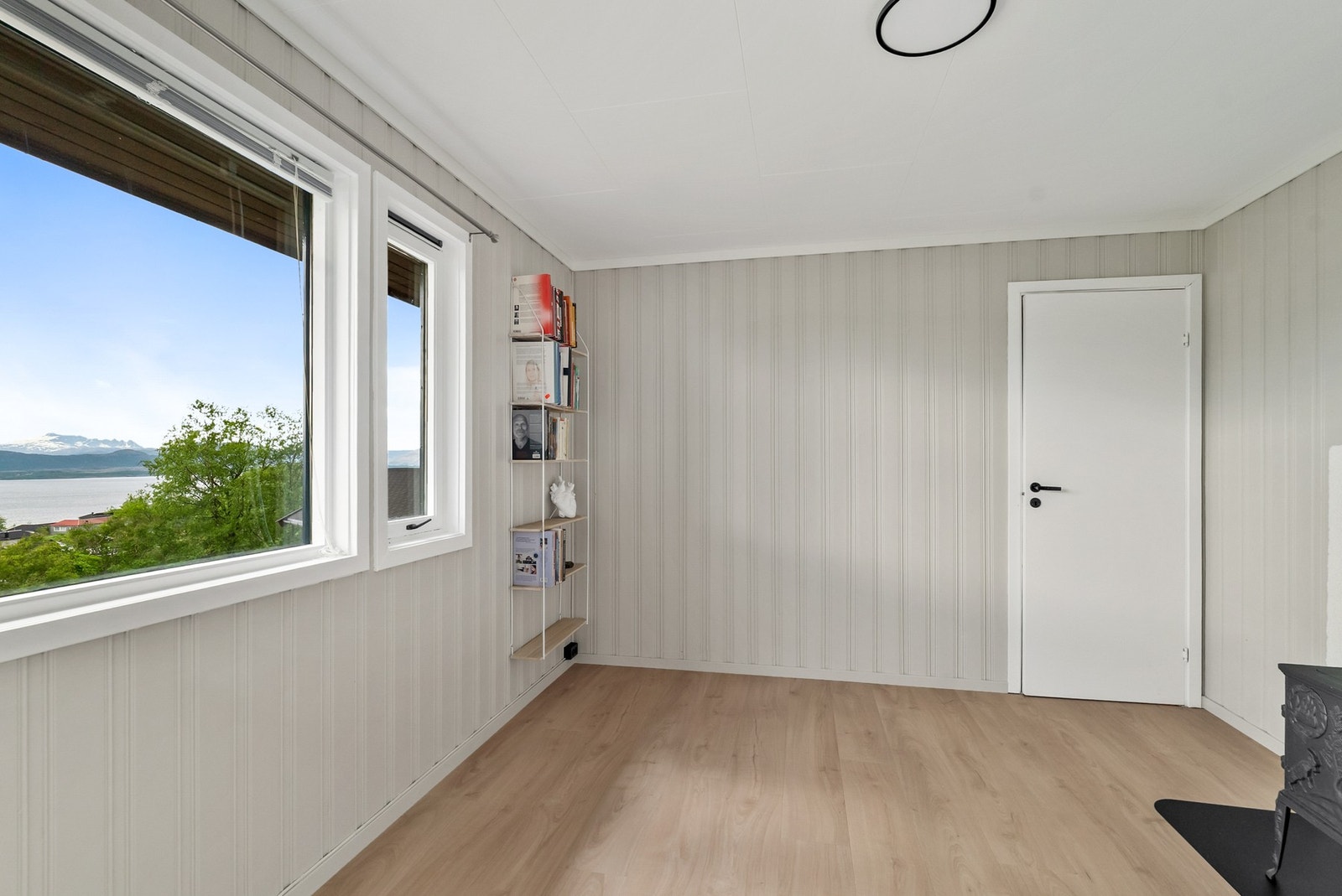 Rommet har panel på veggene og laminat på gulvet. Galleribilde