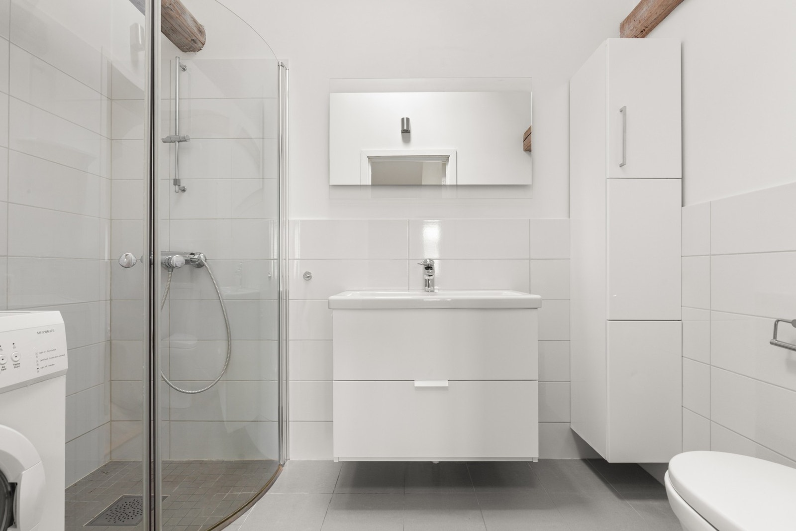 Baderom fra byggeår (2014) med dusj, wc, opplegg for vaskemaskin og servant. Galleribilde