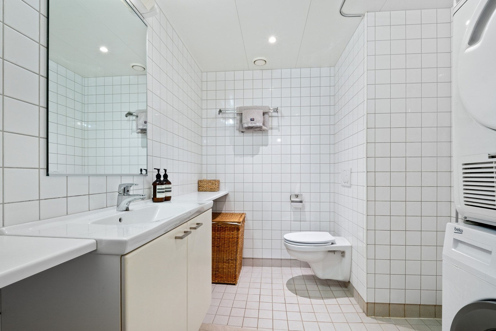 Badet er innredet med servant i baderomsinnredning, vegghengt toalett, dusjløsning med dusjvegger samt opplegg for vaskemaskin. Galleribilde