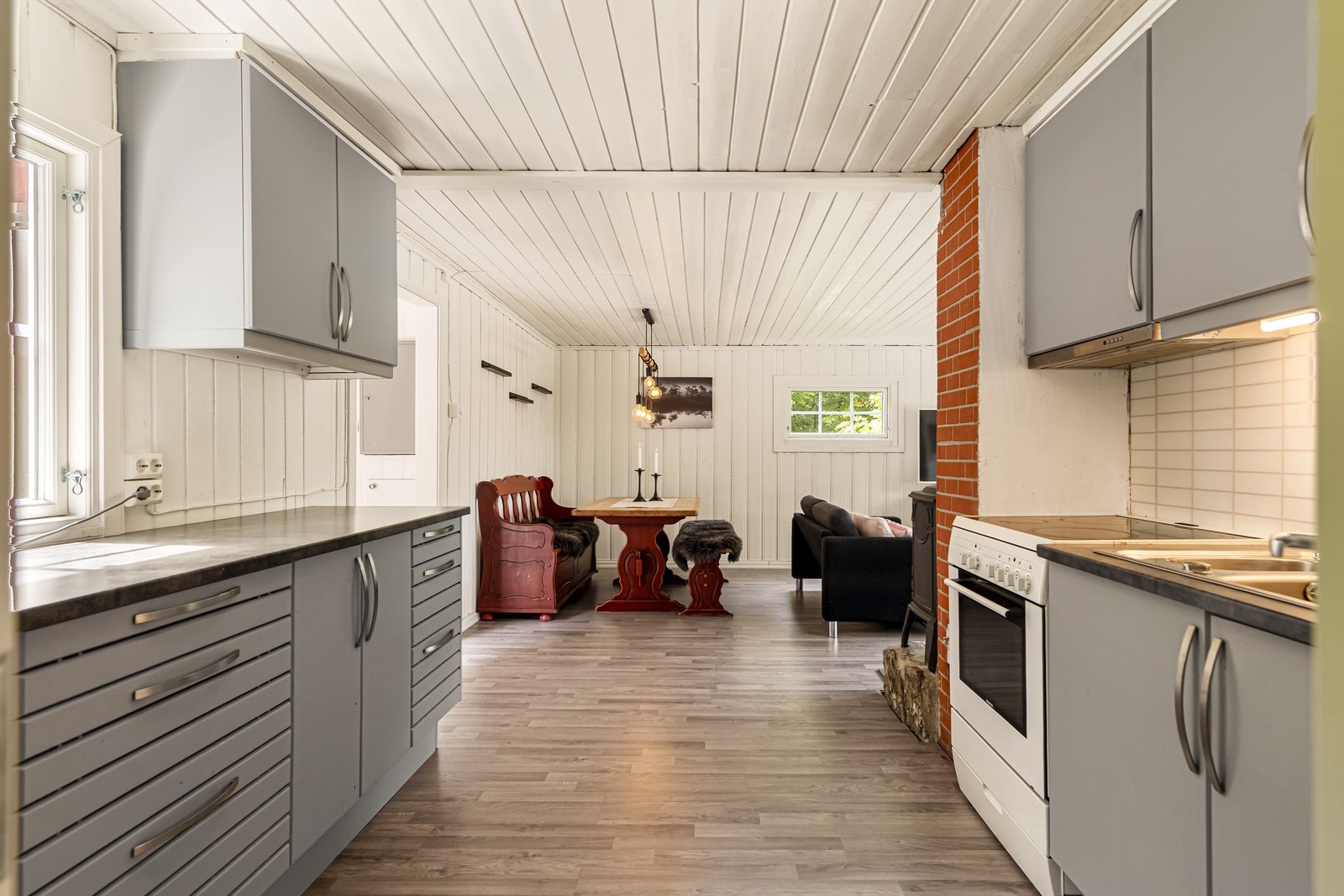 Kjøkkenet ligger i åpen løsning mot stuen og har en funksjonell innredning med glatte fronter og laminert benkeplate. Galleribilde