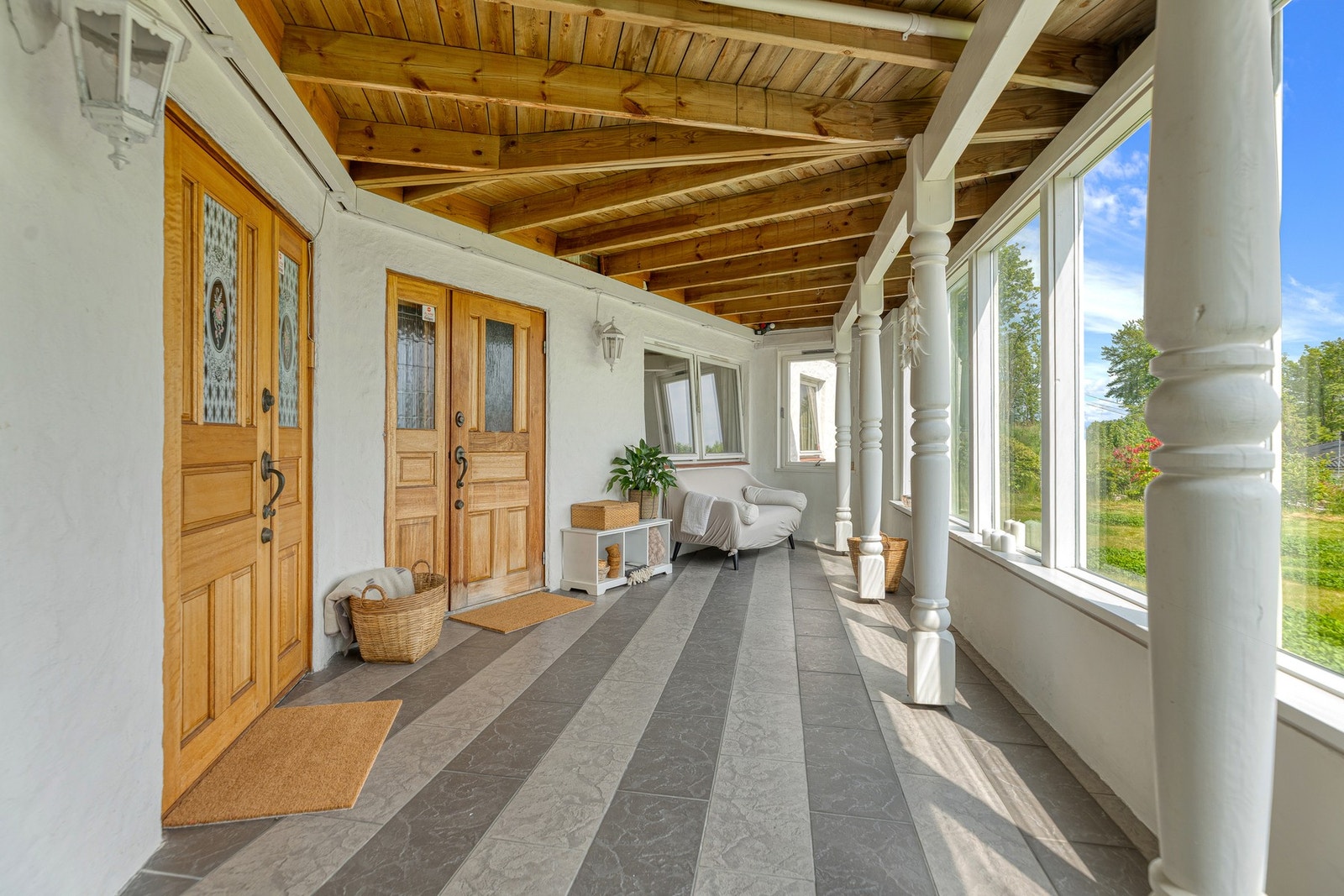 Overbygget inngangsparti til enebolig og til hybelen. er er det god plass til både sittegrupper, spisebord og hyggelige sosiale sammenkomster, uansett vær. Galleribilde