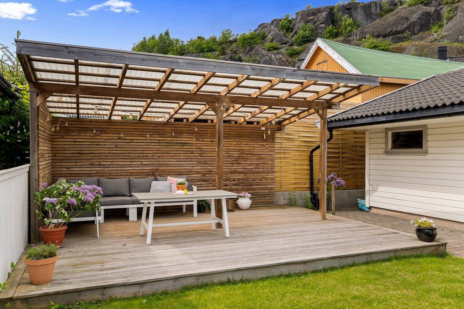 Den store uteplassen er delvis overbygget med en pergola i impregnert treverk. Galleribilde