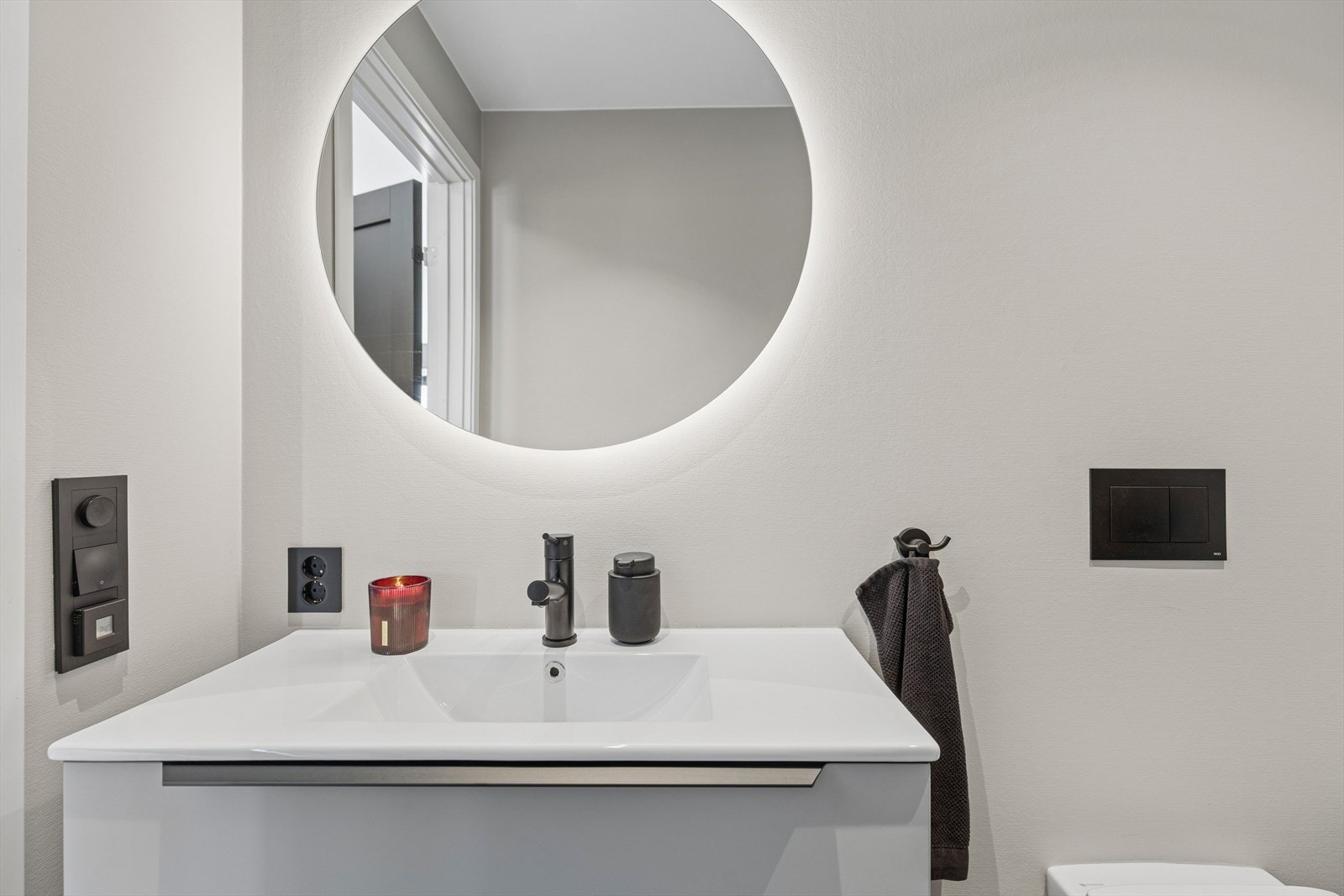 Badet inneholder servant med møbel, toalett og dusj. Galleribilde