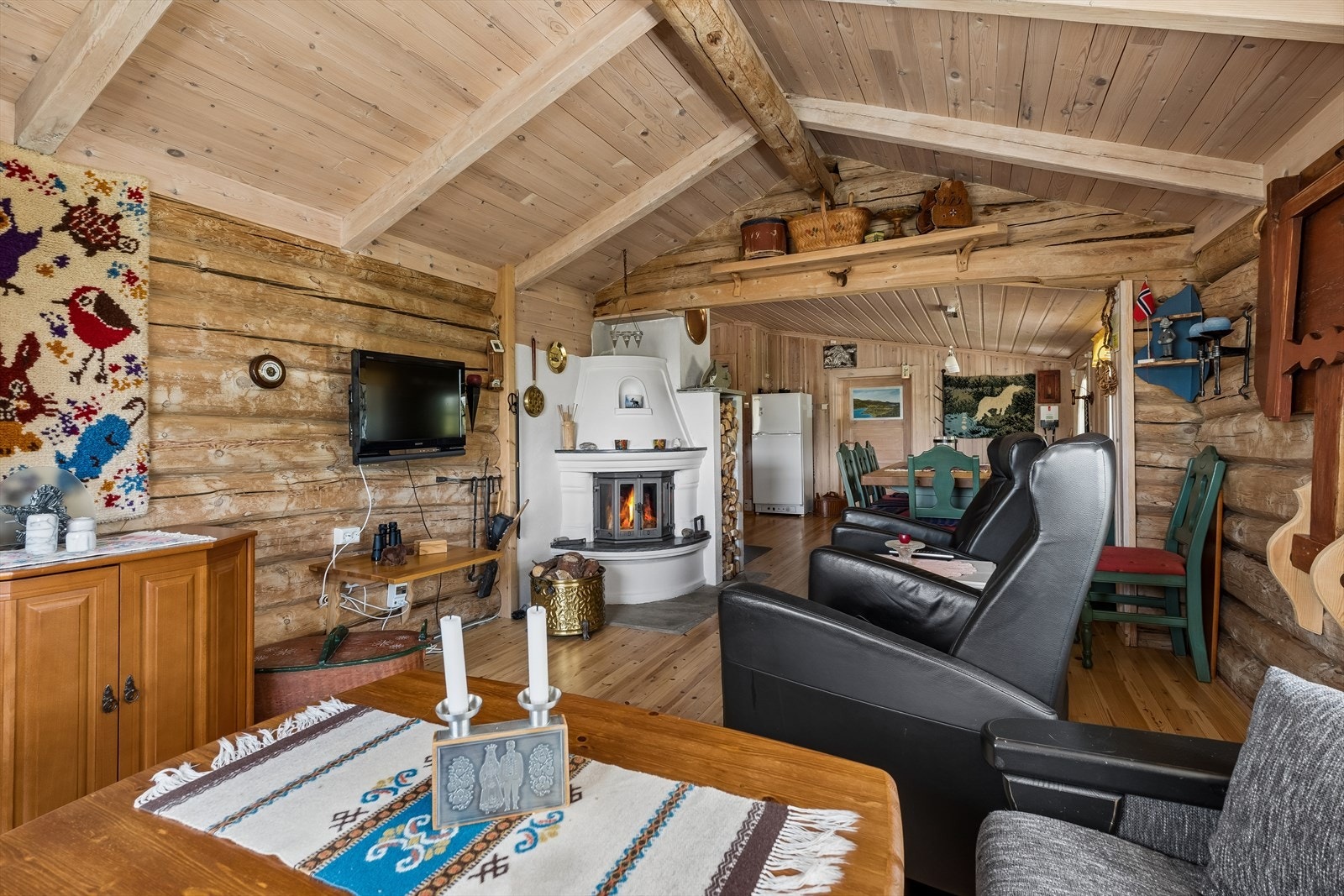 Stuen har en lun atmosfære med synlige laftevegger og god plass til sittegruppe. Galleribilde