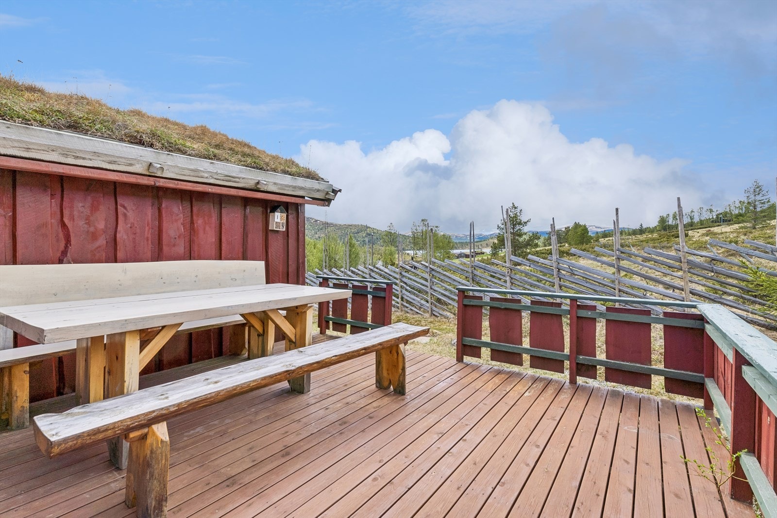 Fra kjøkkenet er det utgang til verandaen på baksiden av hytta, som er en usjenert og fin uteplass. Utsikt mot Lomsjøen. Galleribilde