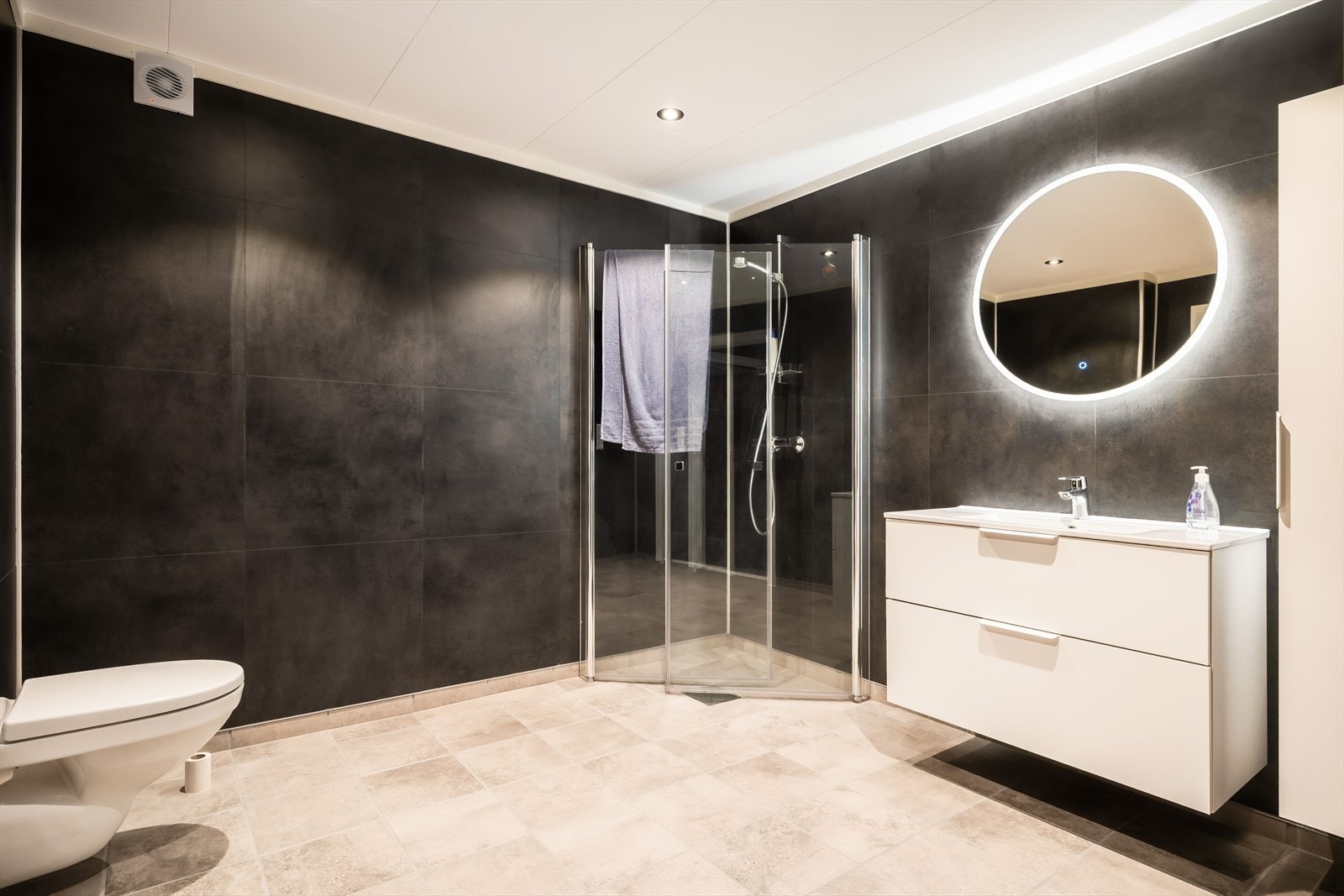 Gjennomførte material- og innredningsvalg gir badet et stilrent og innbydende preg. Det er også varmekabler i gulv. Galleribilde