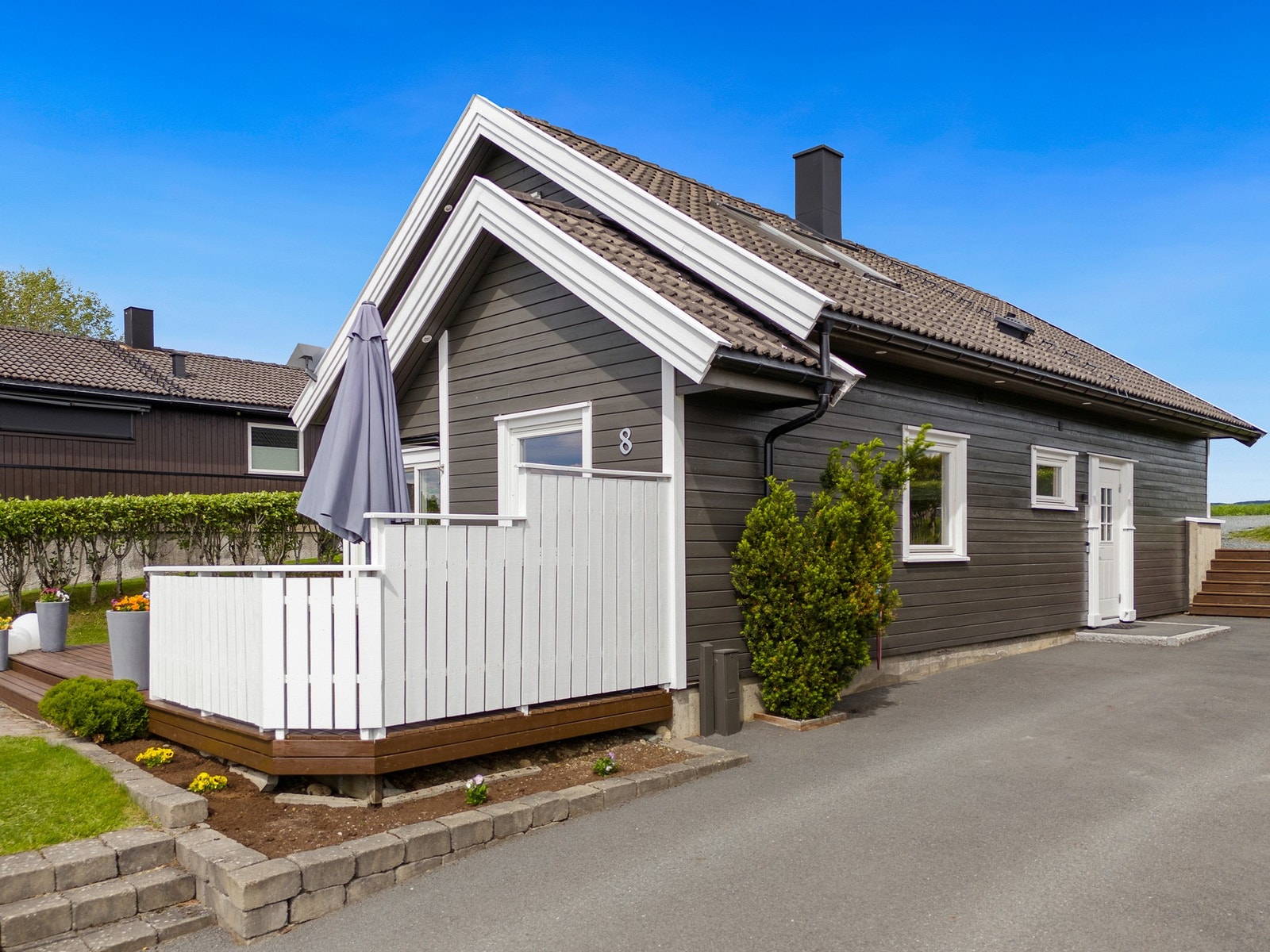 Asfaltert innkjøring på denne siden og pent innrammet med beleggningstein Galleribilde