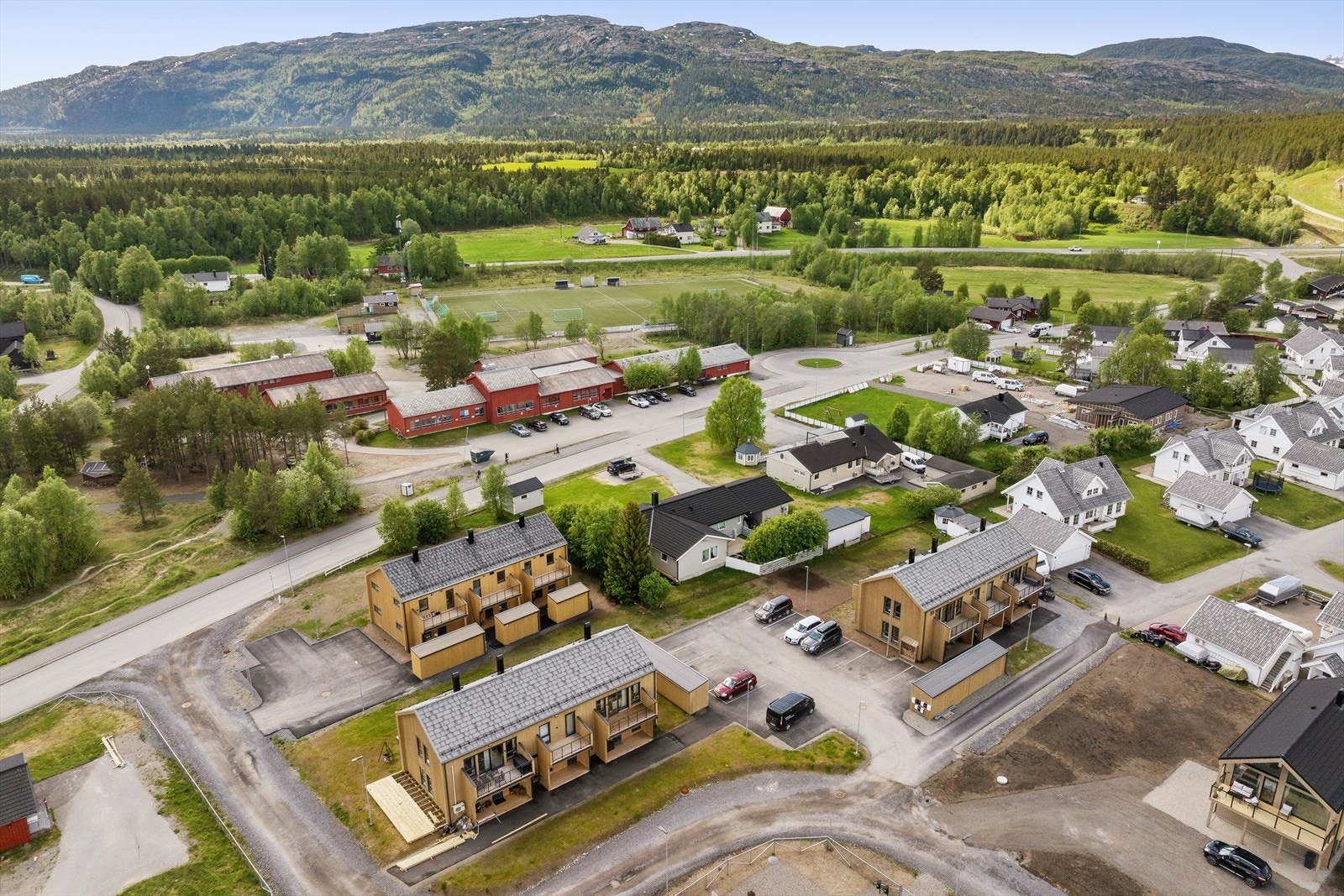 Eiendommen ligger i et etablert boligområde med kort vei til Øvre Alta skole, som er synlig i bakgrunnen. Galleribilde