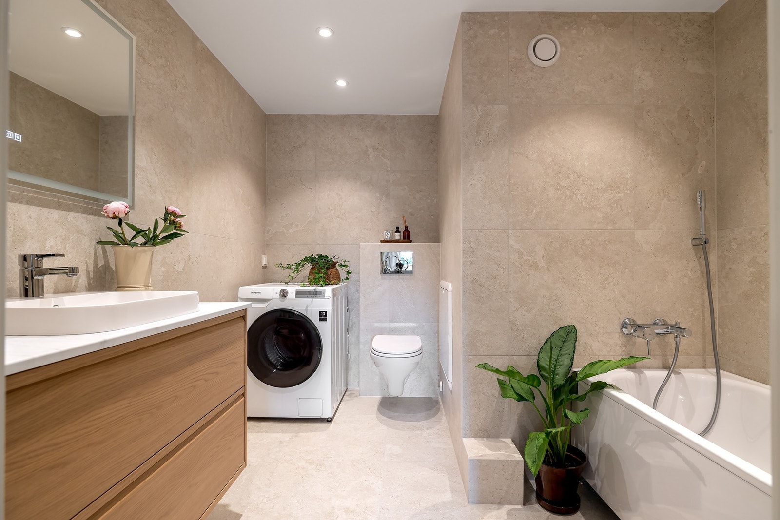 Badet med adkomst fra hovedsoverommet ble pusset opp våren 2026 og har lyse, flislagte overflater, gulvvarme og downlights i himling Galleribilde