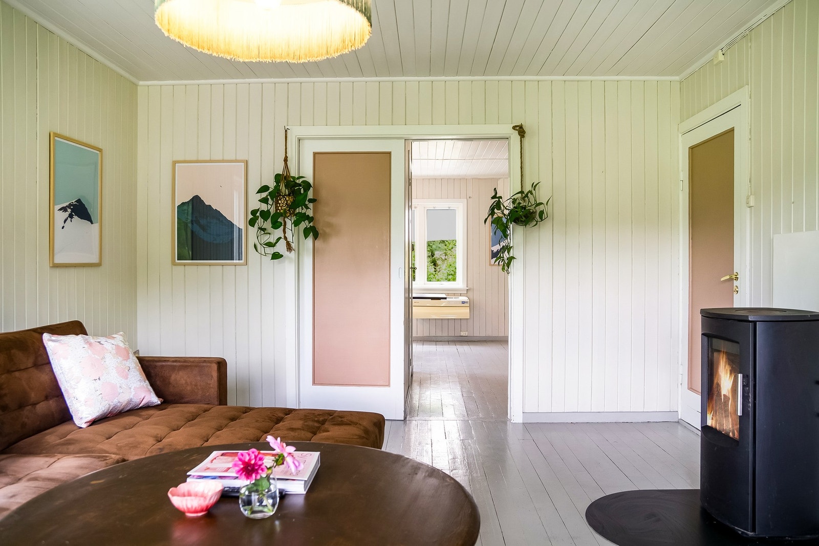 Den moderne vedovnen er plassert sentralt i oppholdsrommet og bidrar med både effektiv oppvarming og et stilrent uttrykk. Galleribilde