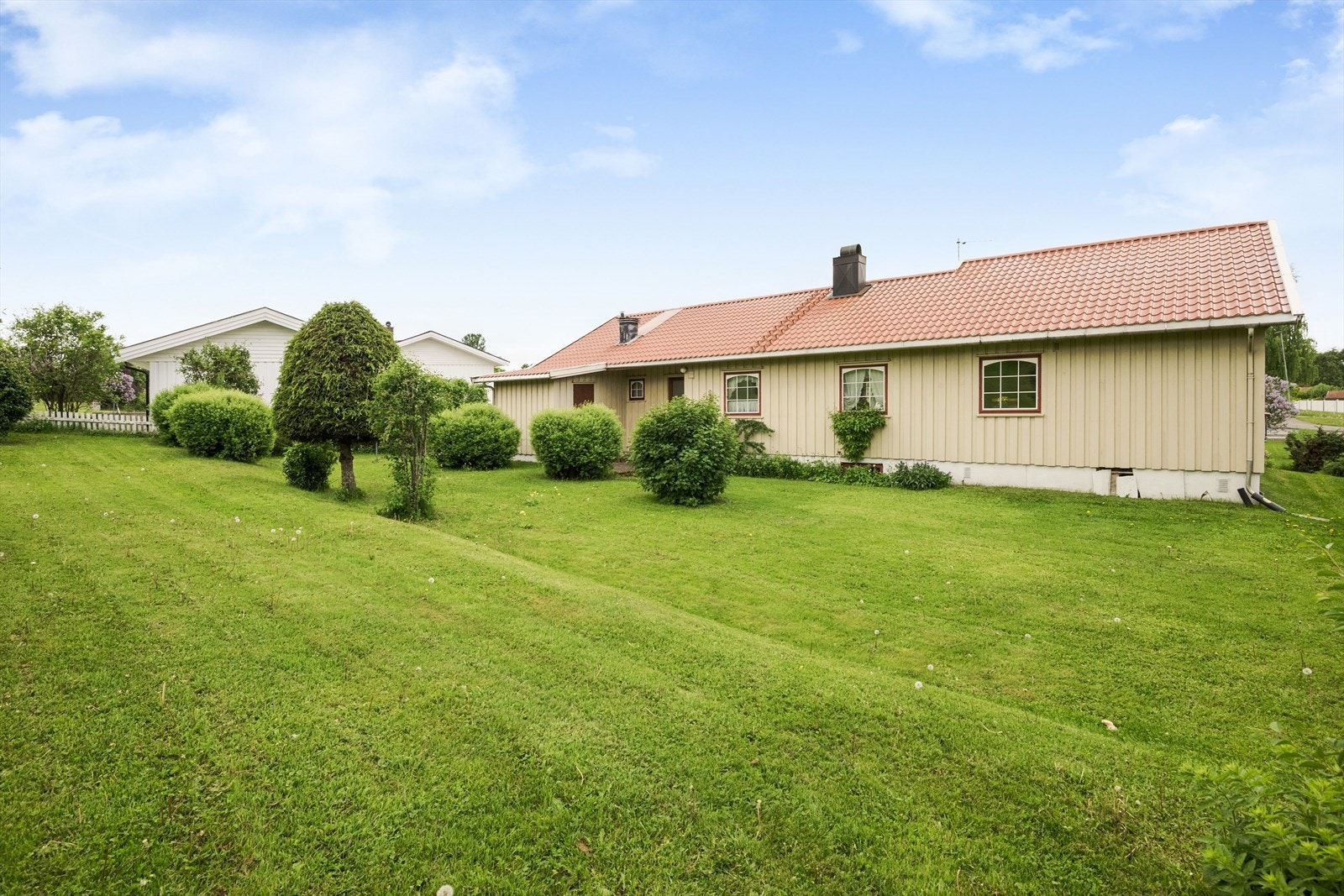 Det er god plass på baksiden av boligen hvor det er en egen utgang. Det er også en praktisk utvendig bod på ca. 8 m² her. Galleribilde