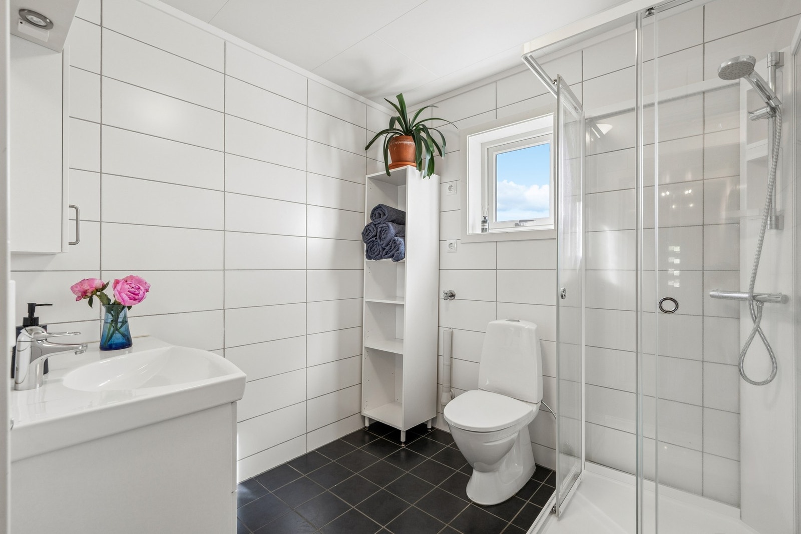 Rommet er utstyrt med dusjkabinett, gulvmontert toalett og opplegg for vaskemaskin. Galleribilde
