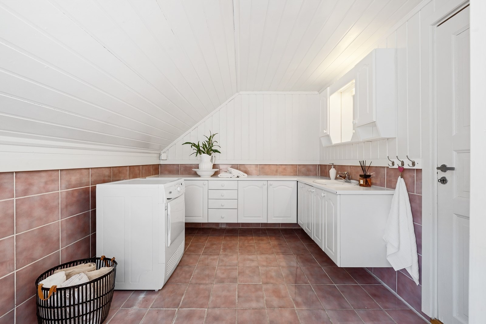Badet fungerer også som vaskerom, med opplegg for vaskemaskin og praktisk benkeplass. Galleribilde
