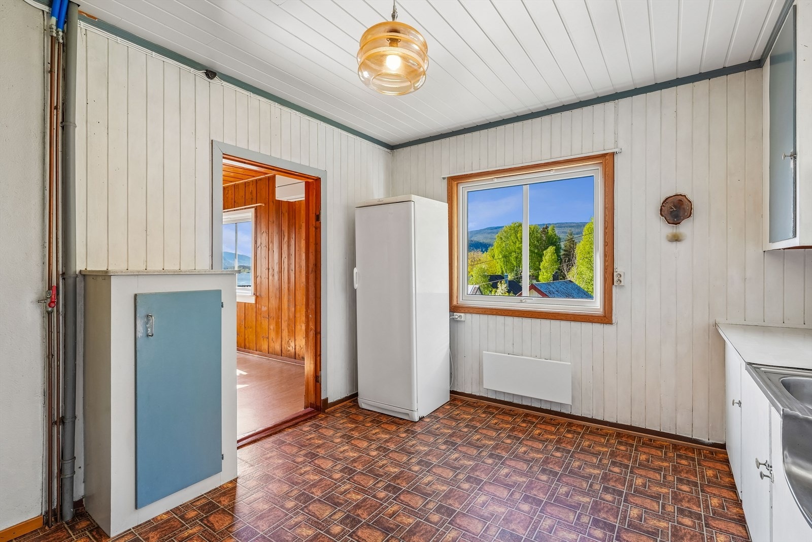 Kjøkkenet har eldre innredning med malte fronter, over- og underskap, laminat benkeplate og oppvaskkum i stål. Galleribilde