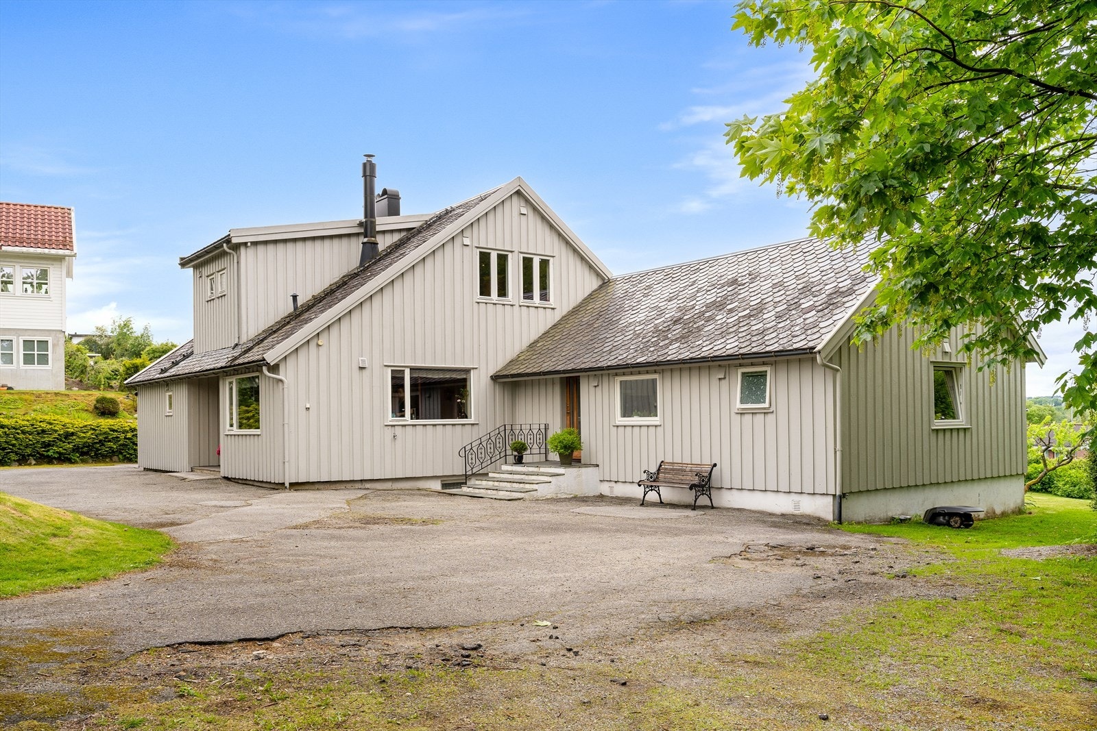 Gårdsplass med god plass til parkering for flere biler og inngang til utleiedel. Galleribilde