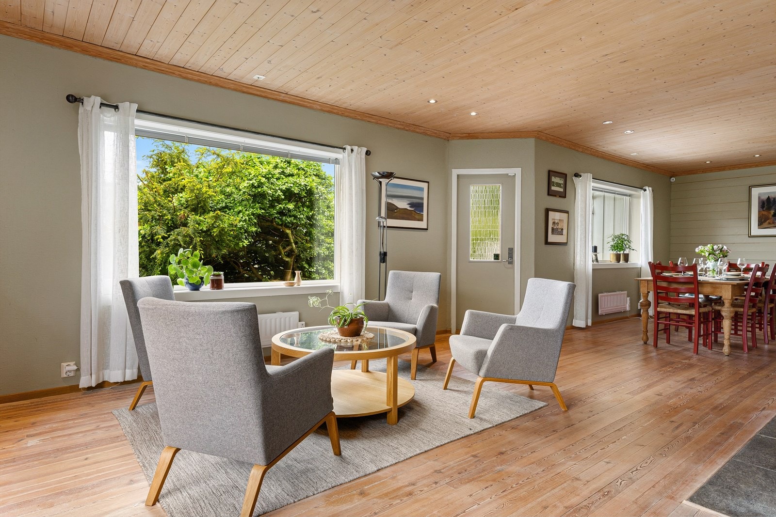 Store vindusflater gir rikelig med lys og binder stuen sammen med spisestuen. Galleribilde