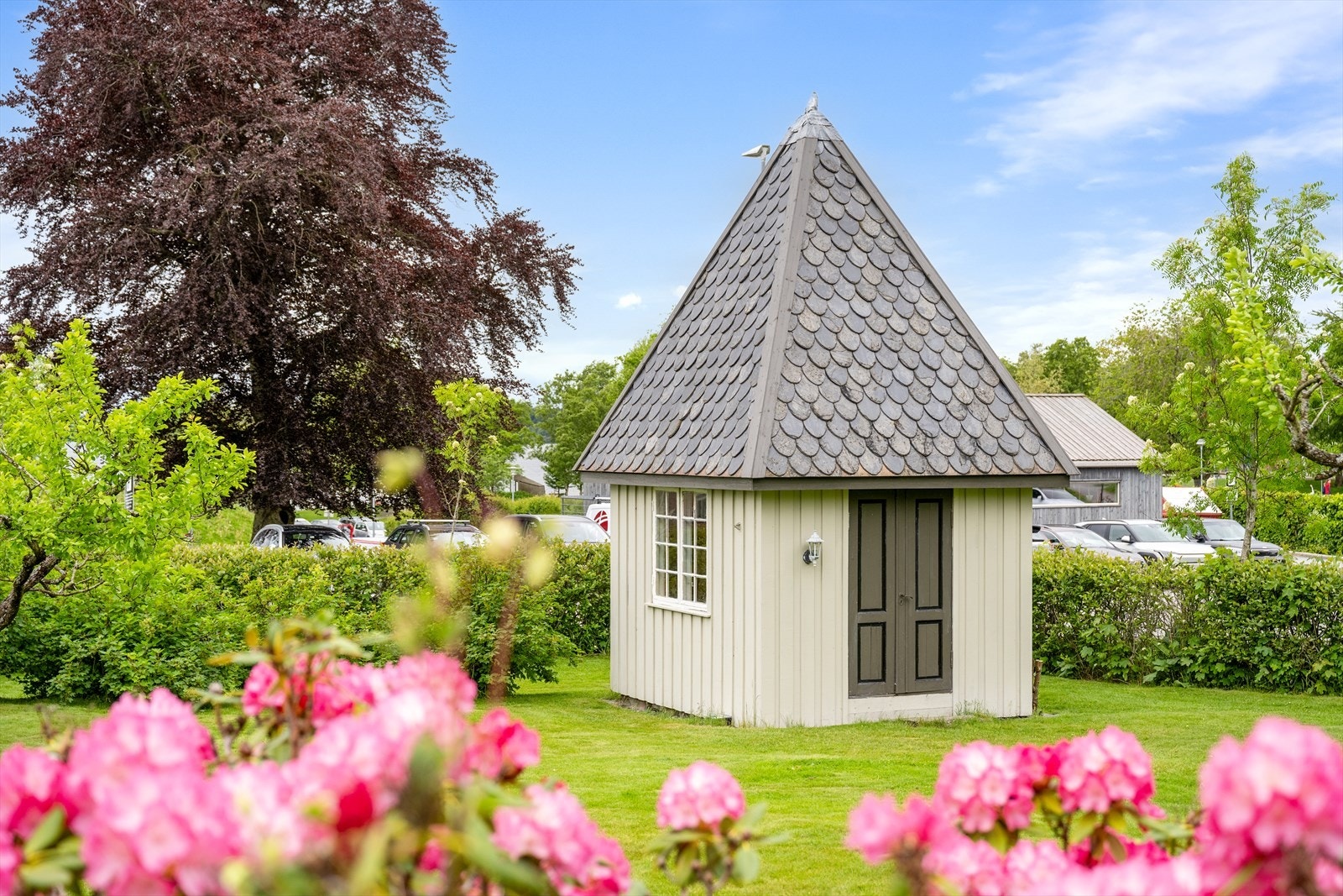 I hagen står et sjarmerende lysthus med skifertak, perfekt for sosiale sammenkomster. Galleribilde