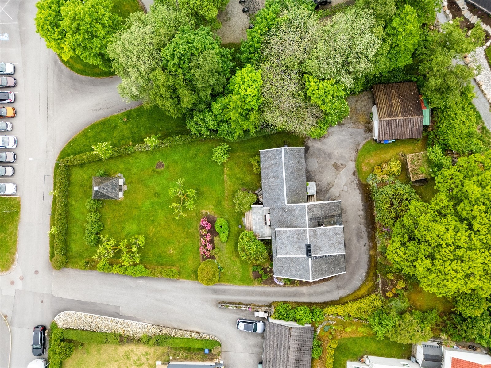 Oversiktsbilde som viser den store tomten med bolighus, garasje og lysthus. Lekehytte er fjernet etter fotografering og følger ikke med i handelen. Galleribilde