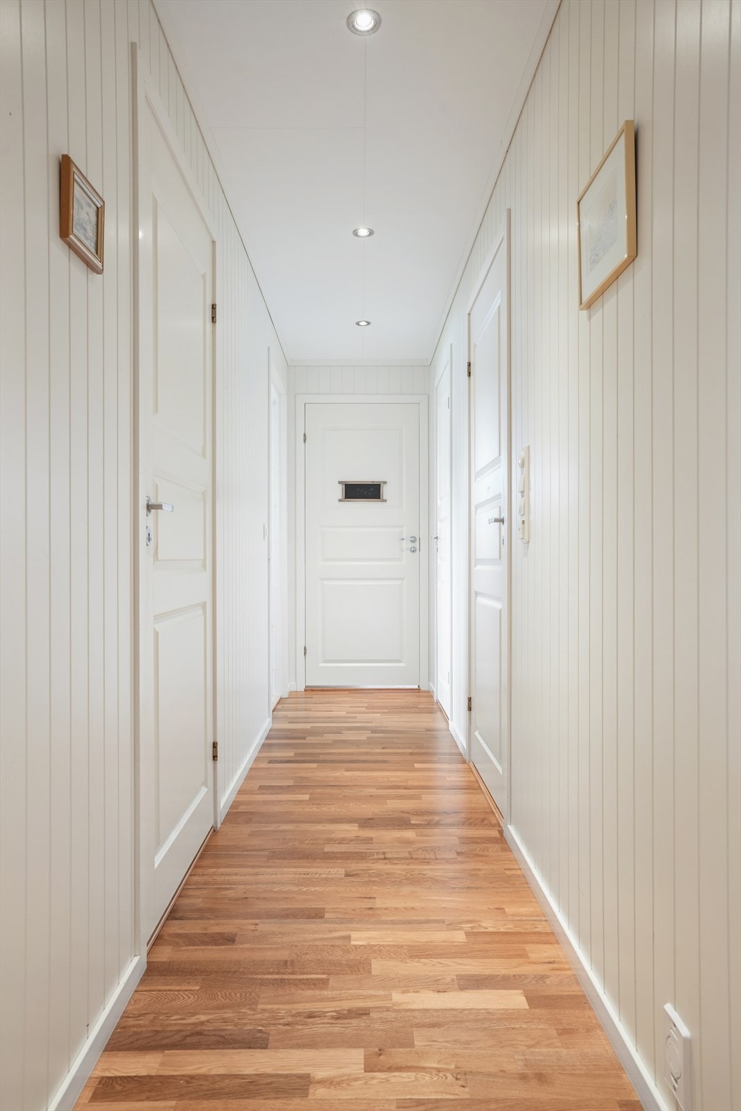 Gjennomgående parkett og lyse panelvegger skaper en helhetlig stil i boligen. Galleribilde