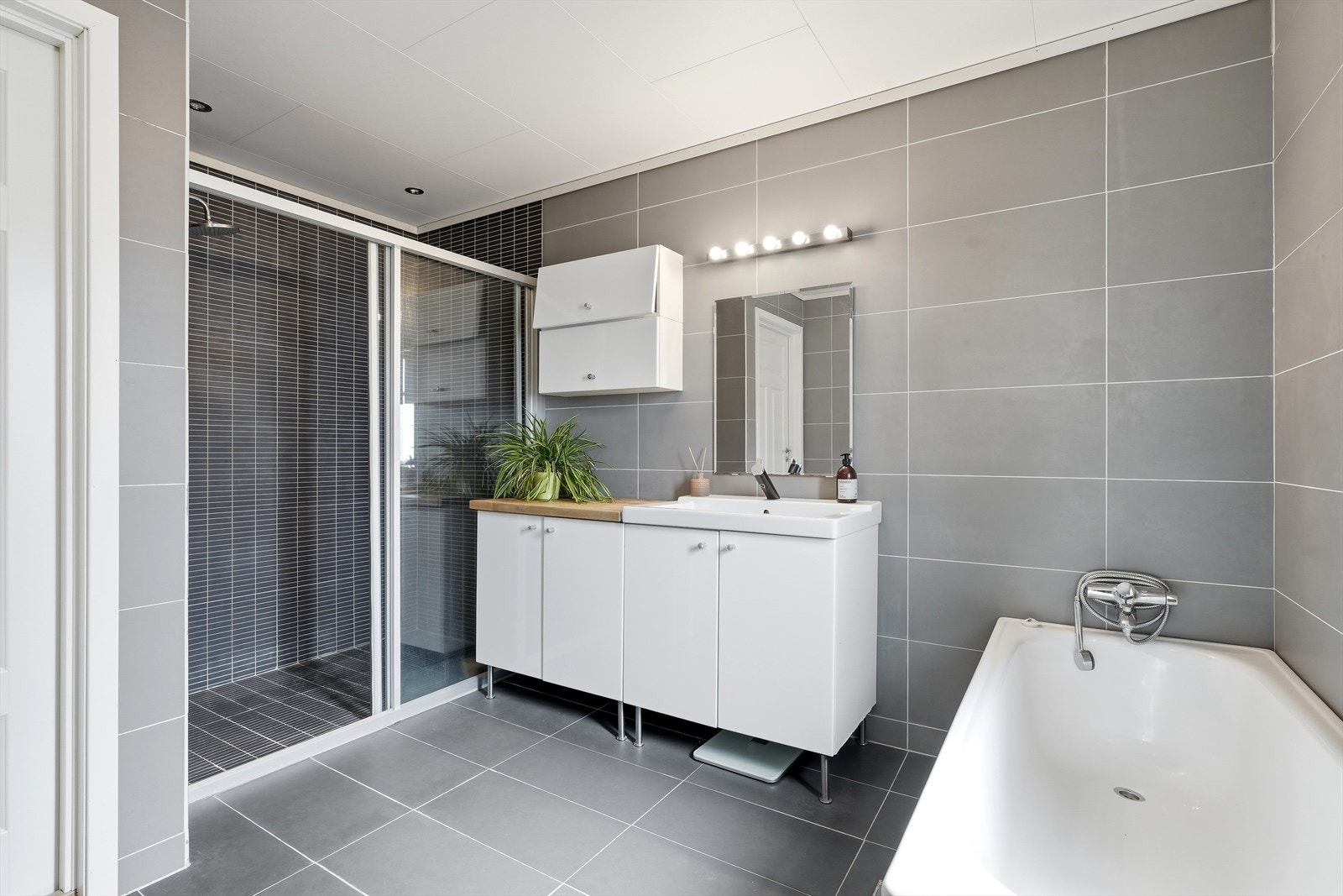 Badet i første etasje er fra byggeåret og utstyrt med både badekar og dusjhjørne. Galleribilde