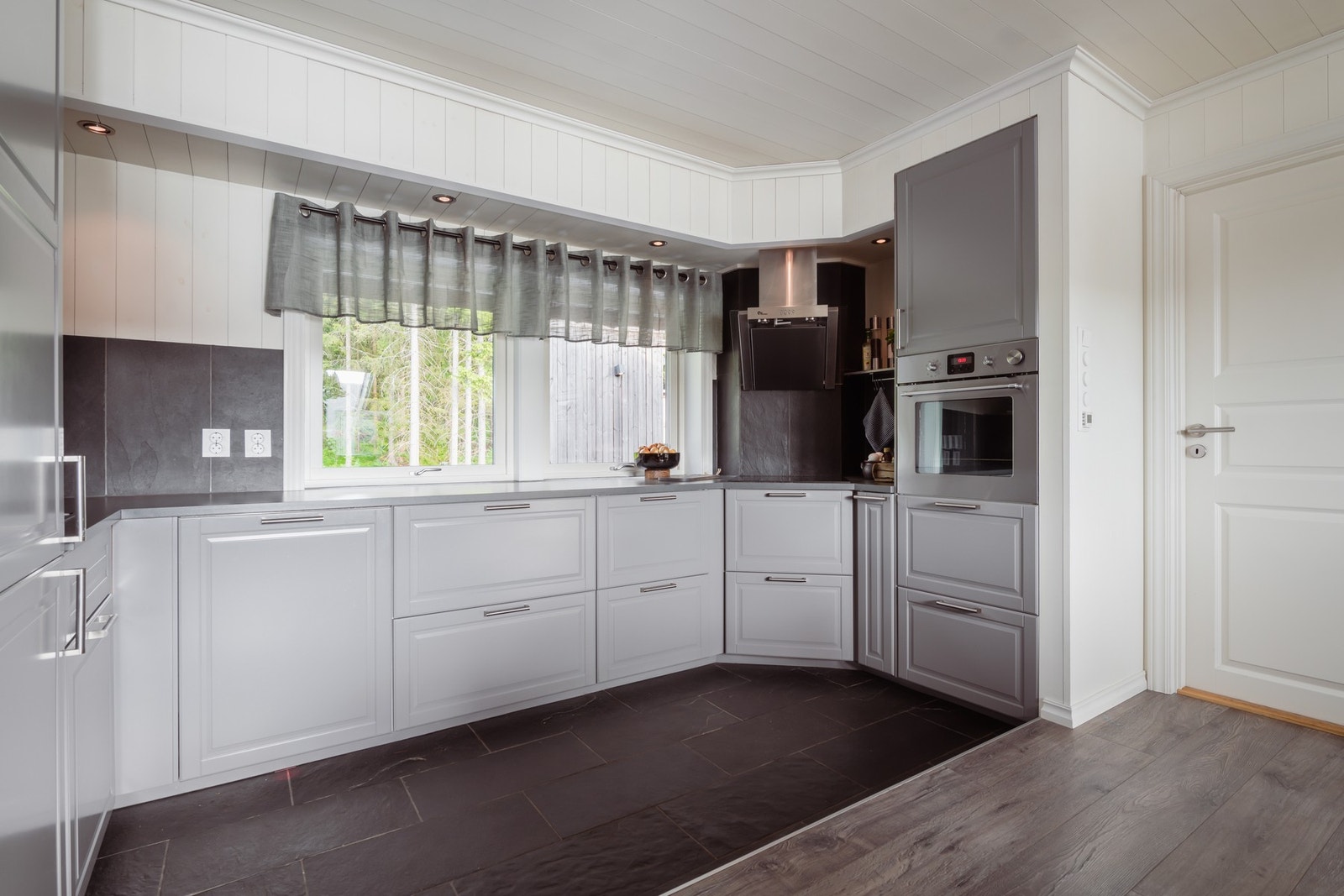 Innredningen ble montert i 2016, med grå, profilerte fronter, nedfelt oppvaskkum og laminert benkeplate i mørkt design. Galleribilde