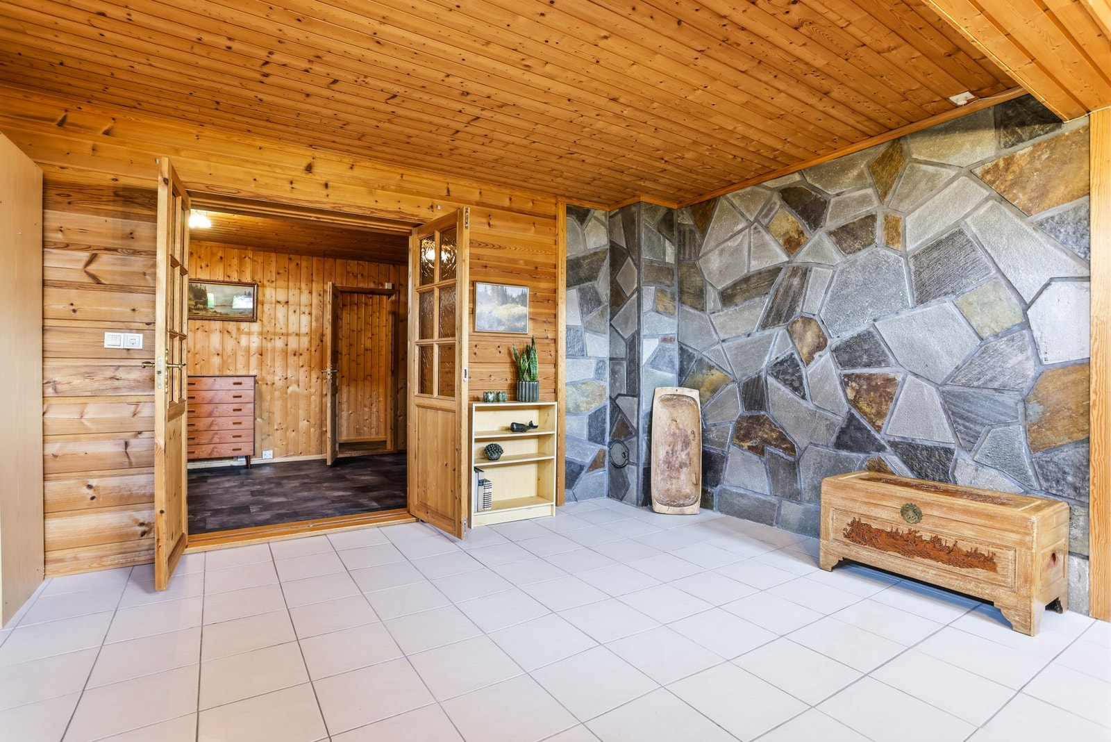 I kjelleren er det en romslig og koselig kjellerstue med en kombinasjon av skifer og naturlig panel på veggene, og med hvite fliser på gulvet. Det er god plass til sofagruppe, lenestoler og TV. Rommet er et kjærkomment element for barnefamilier. Galleribilde