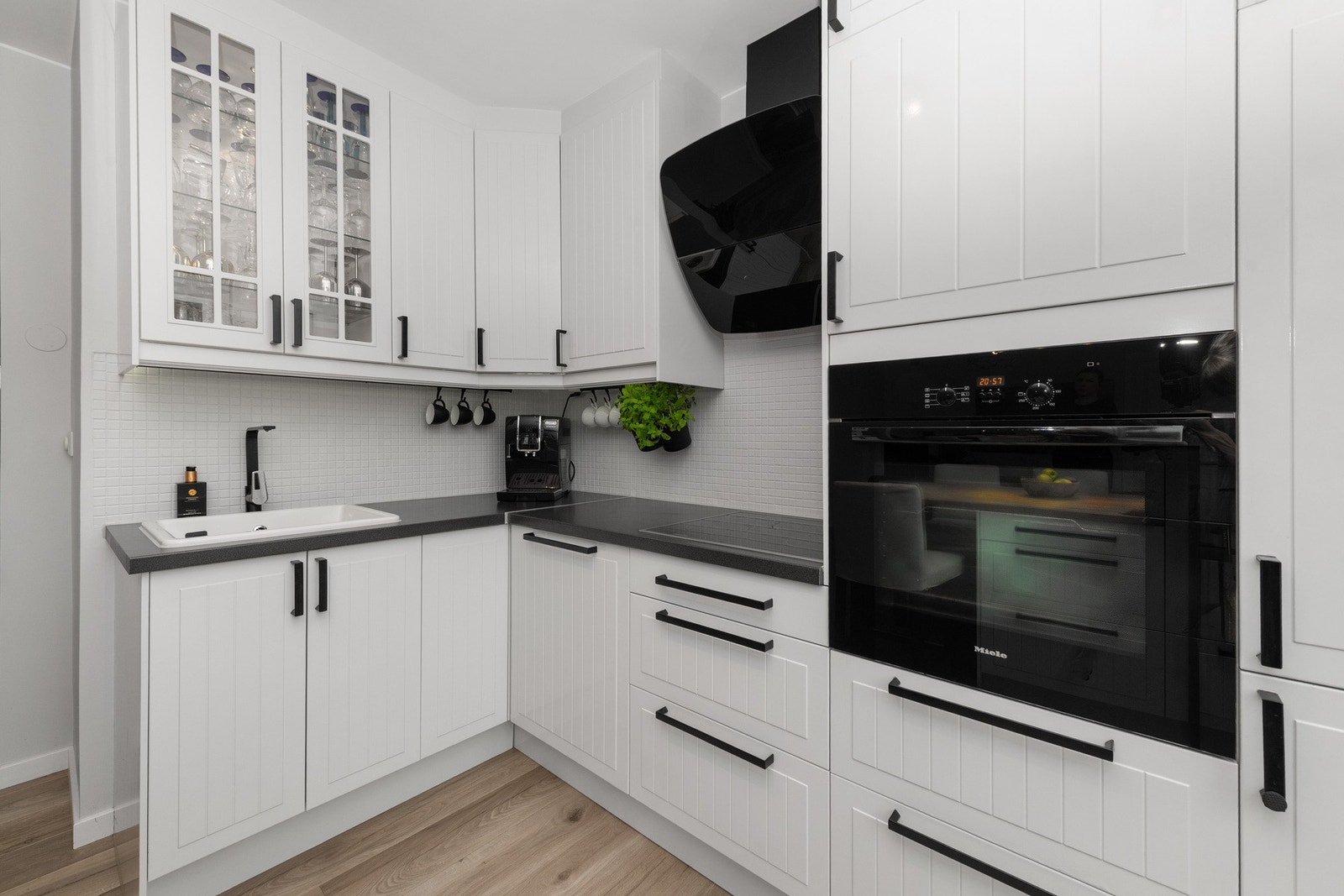 Benkebelysning bidrar til et moderne og gjennomført uttrykk, mens mosaikkfliser over benkeplaten gjør overflatene både praktiske og enkle å vedlikeholde. Galleribilde