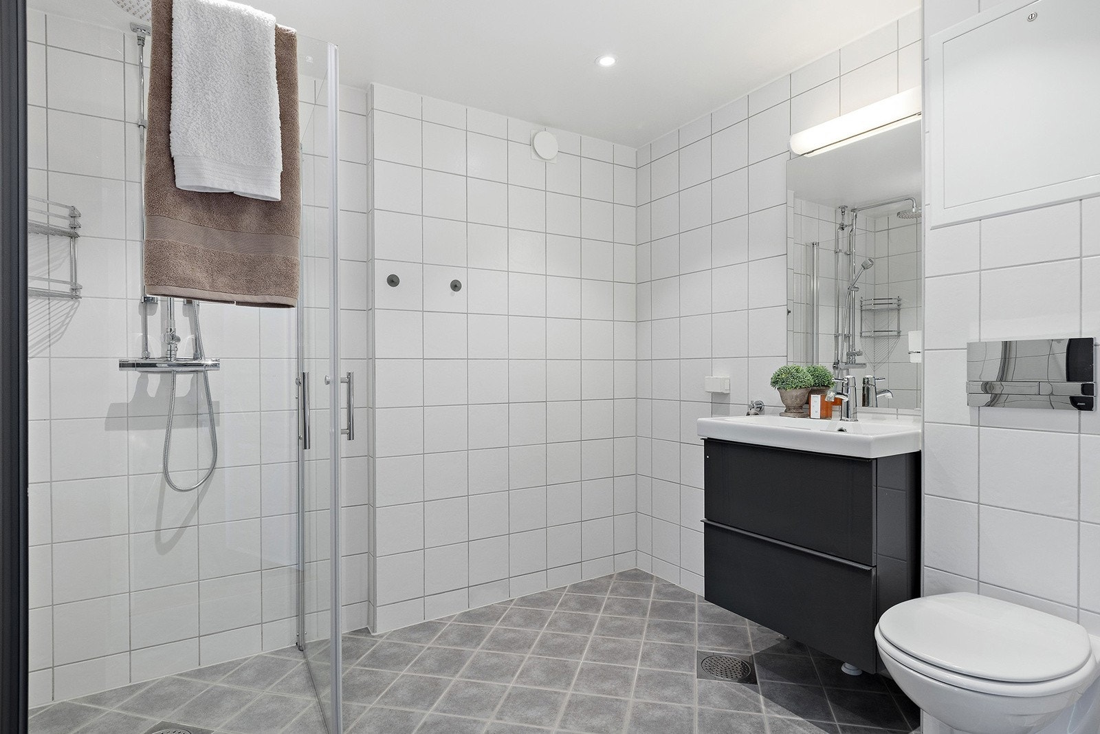 Romslig bad med opplegg for og god plass til vaskemaskin og tørketrommel. Galleribilde