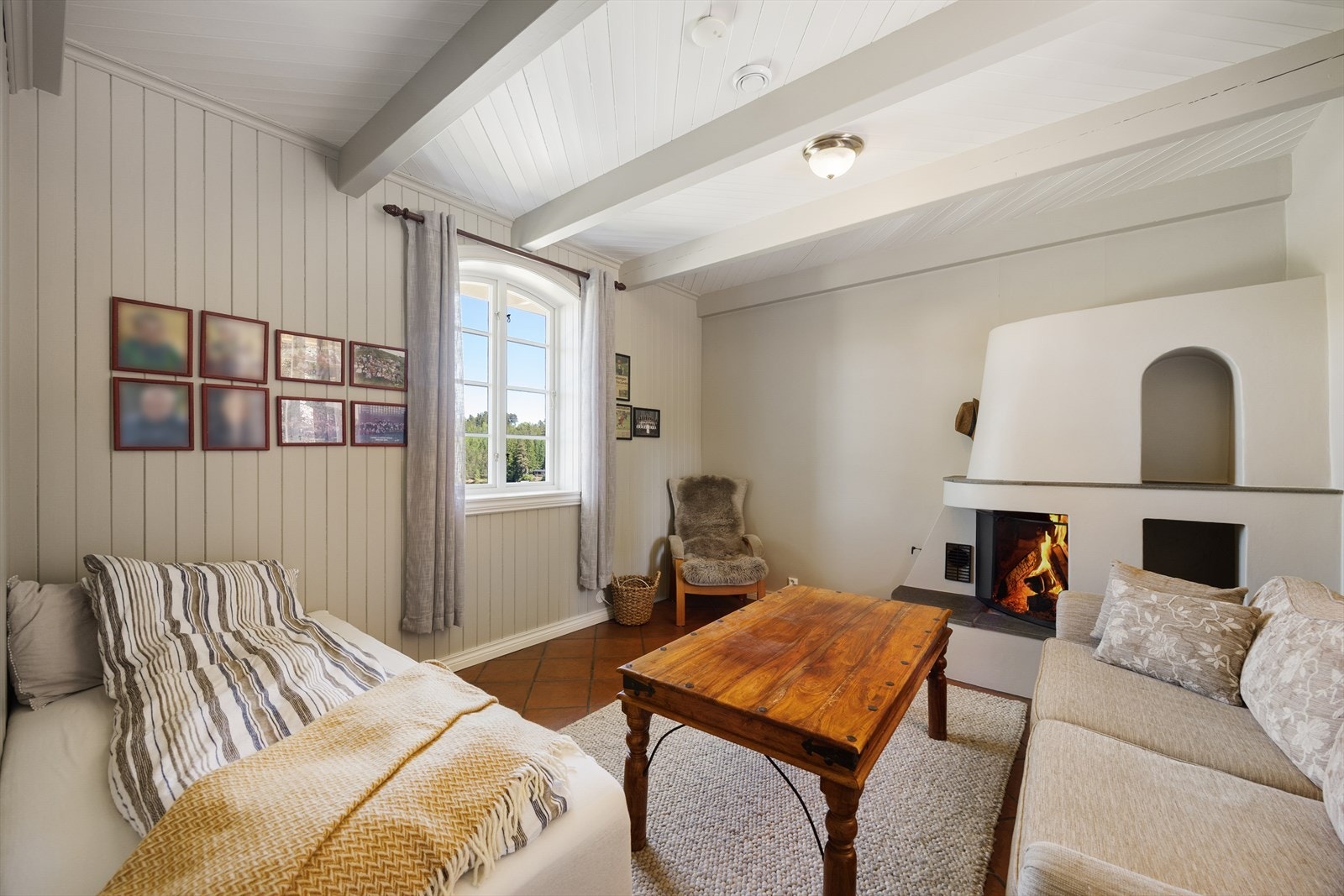 Et av rommene i første etasje, her innredet som en ekstra stue med peis. Galleribilde
